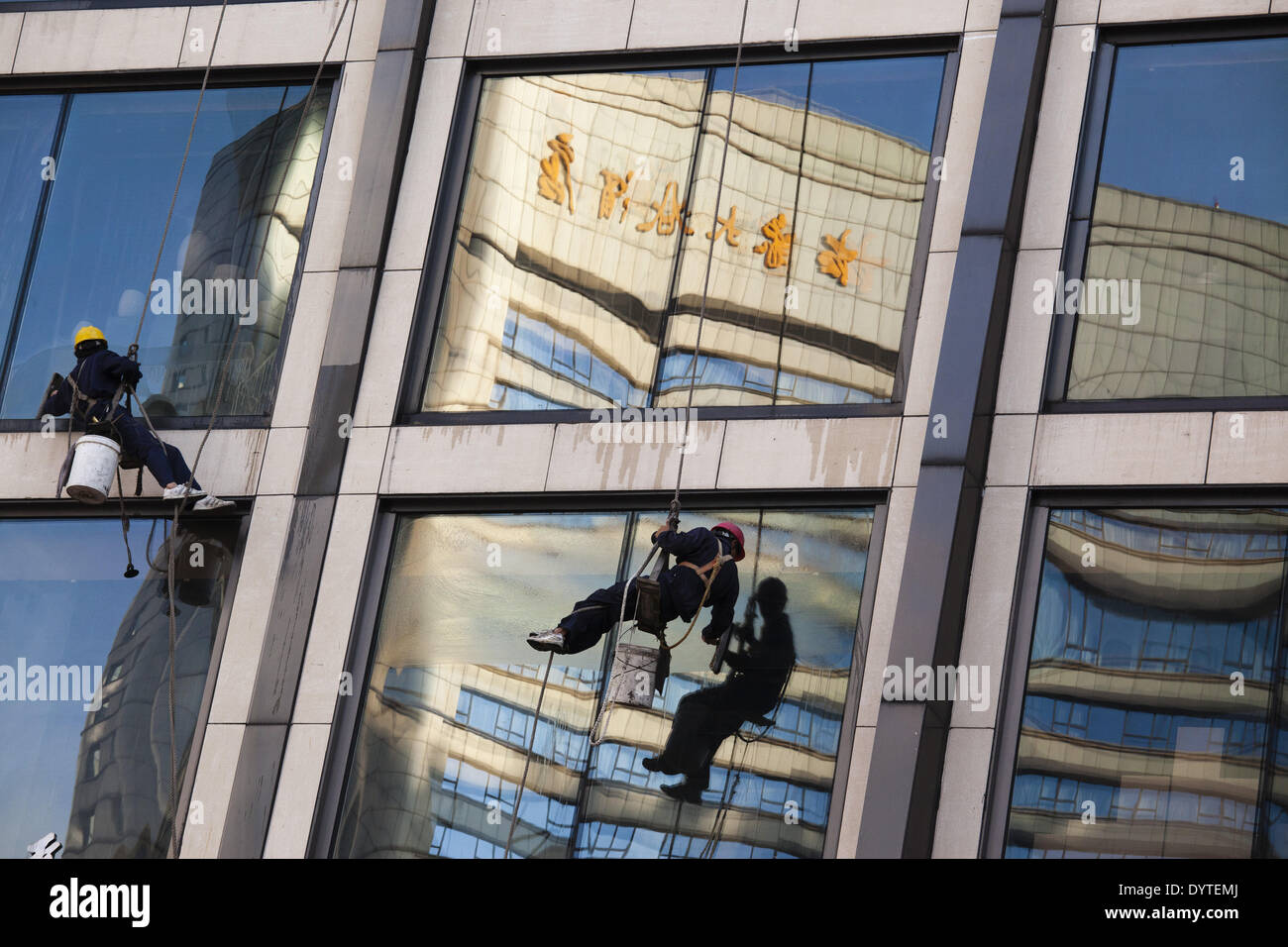Two workers clean the exterior of a building hi-res stock photography ...