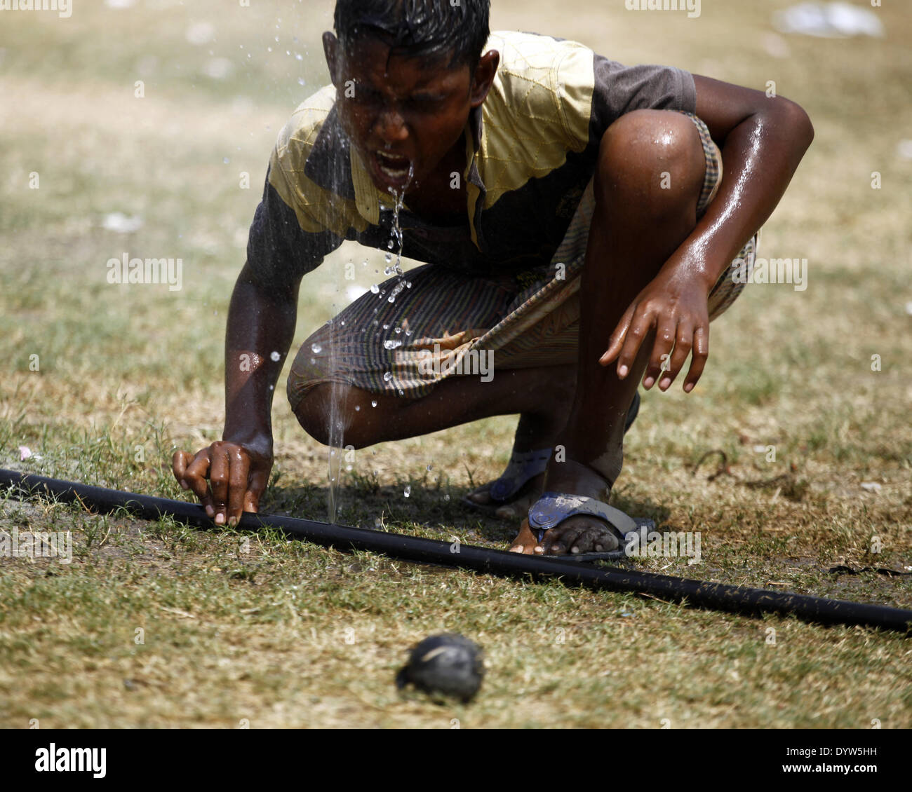 Dhaka, Bangladesh. 25th Apr, 2014. A boy drinking water from water pipe while playing on field.People in the capital experienced the hottest day in the last 54 years as the mercury shot up to 40.7 degrees Celsius yesterday, the Met office says.The previous highest temperature in the capital was recorded 42.3 degrees on April 30, 1960, according to Bangladesh Meteorological Department. The highest temperature on April 24 last year in Dhaka was 34.2 degrees. Credit:  Zakir Hossain Chowdhury/NurPhoto/ZUMAPRESS.com/Alamy Live News Stock Photo