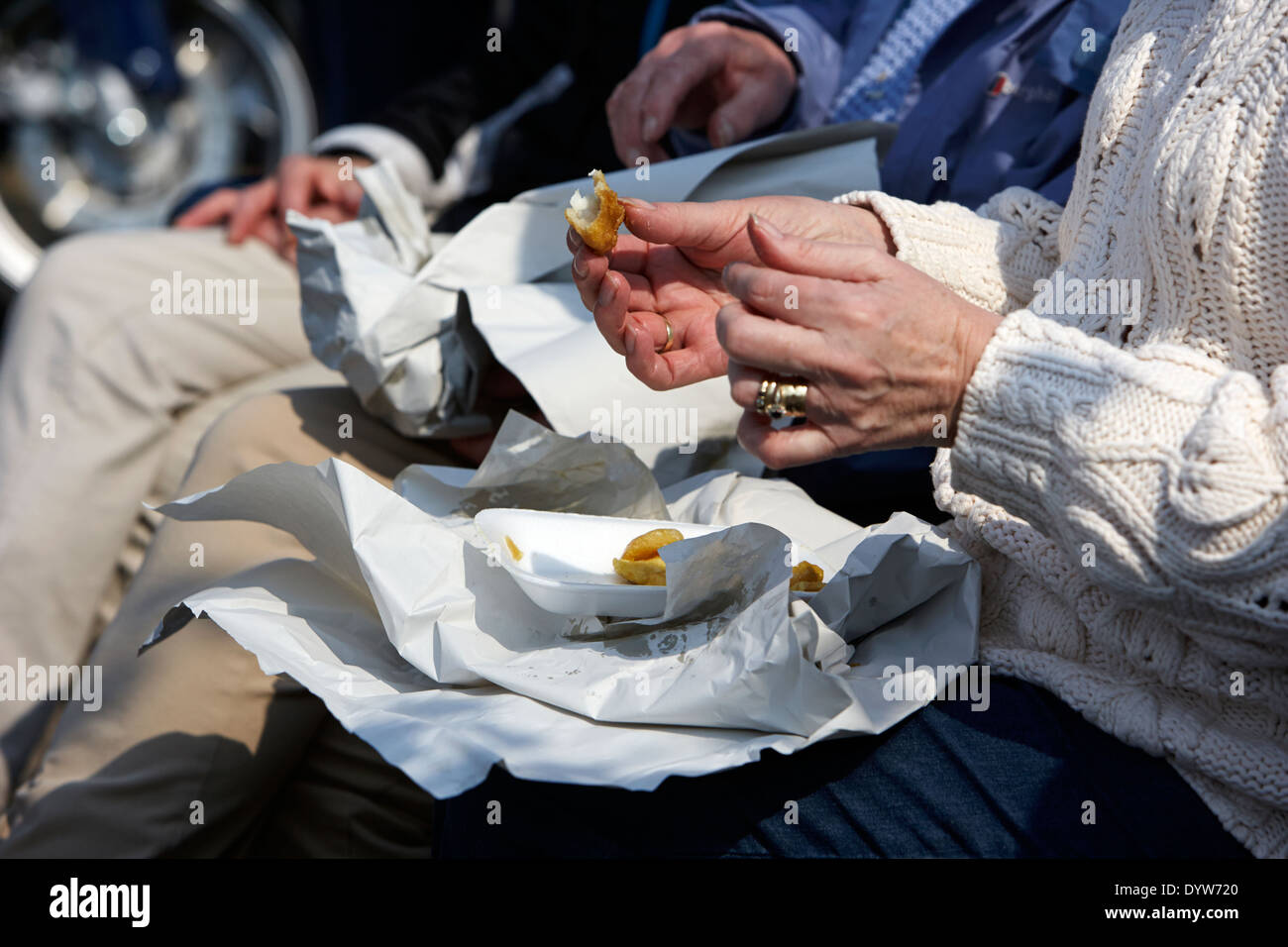older woman eating fish and chips on a sunny day in the uk Stock Photo