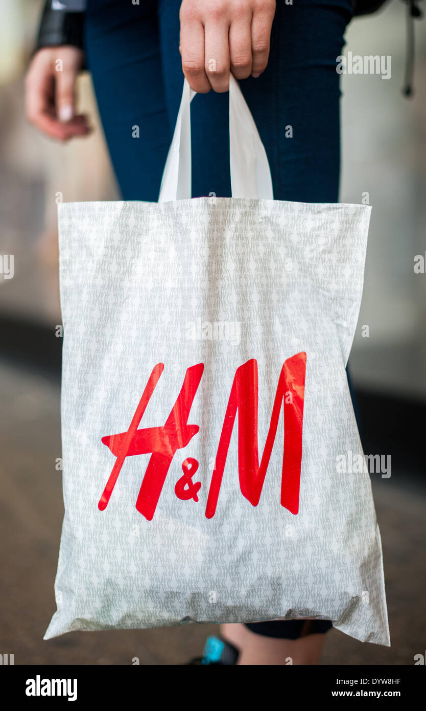 A man holds a plastic bag of the retail clothing company Hennes & Mauritz ( H&M) in Berlin, Germany, 23 April 2014. Photo: Hauke-Christian Dittrich/dpa  Stock Photo - Alamy