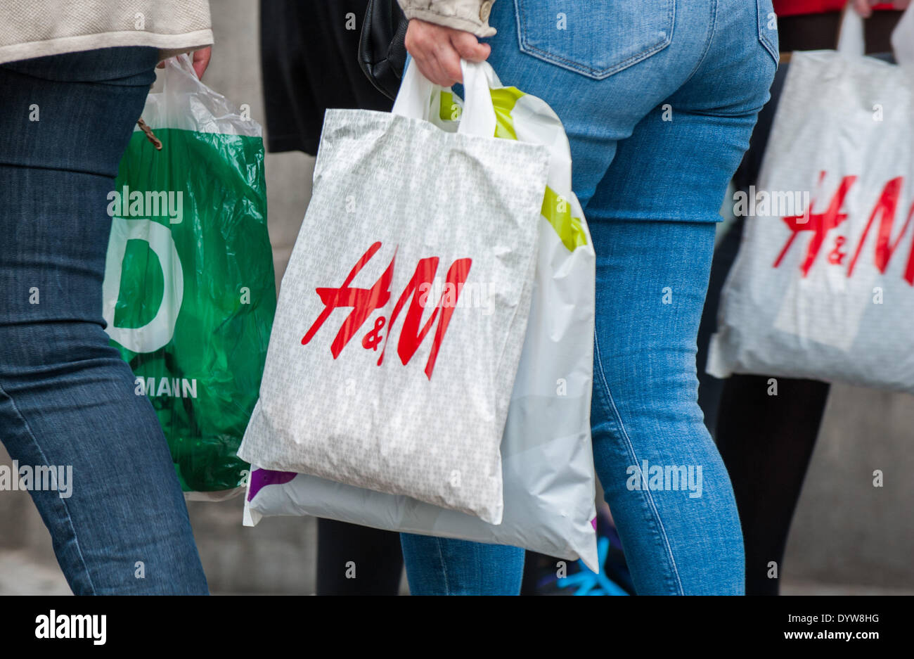 People hold plastic bags of the retail clothing company Hennes & Mauritz ( H&M) in Berlin, Germany, 23 April 2014. Photo: Hauke-Christian Dittrich/dpa  Stock Photo - Alamy