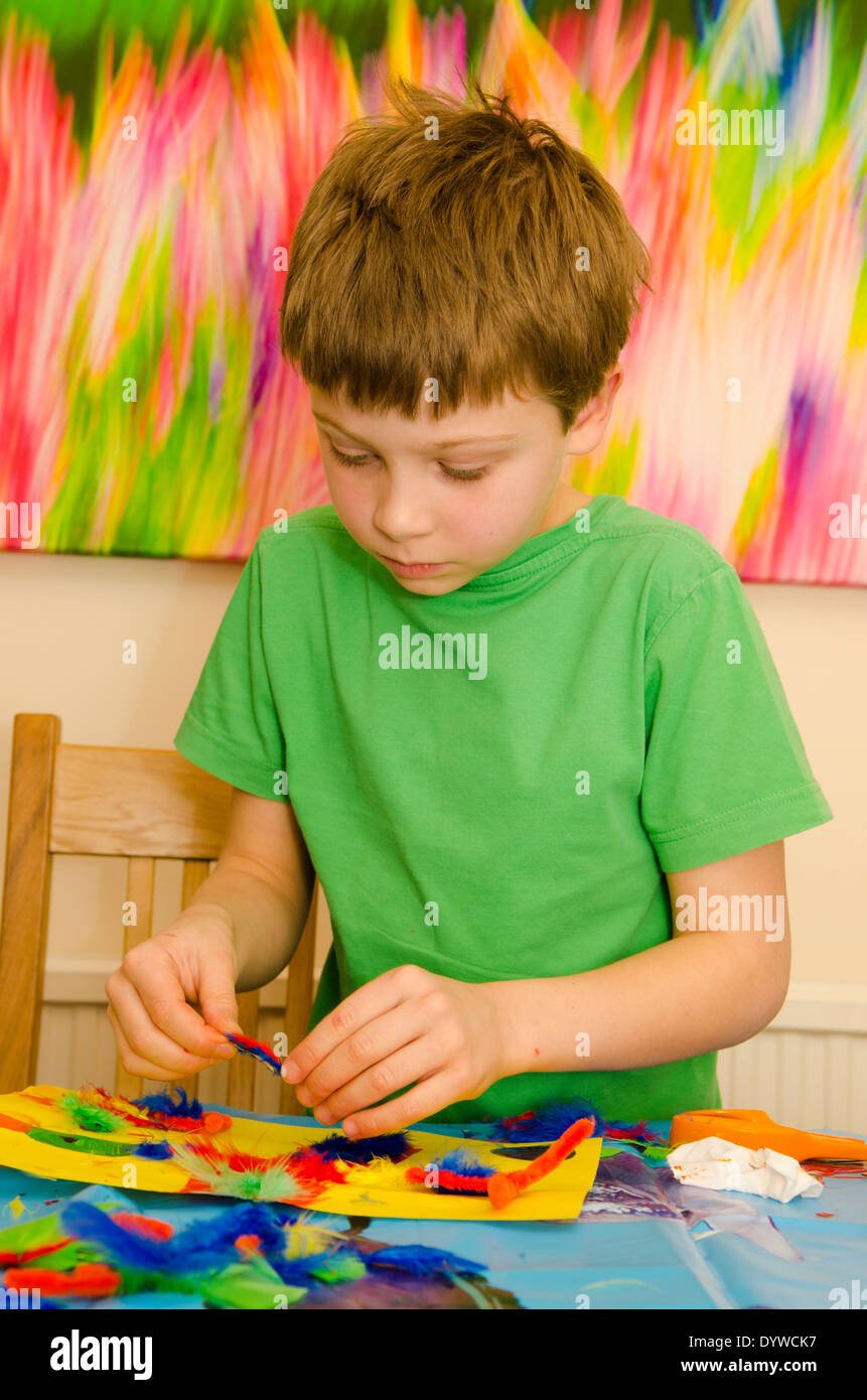 eight year old boy doing arts and craft montage with glue scissors and paint Stock Photo Alamy