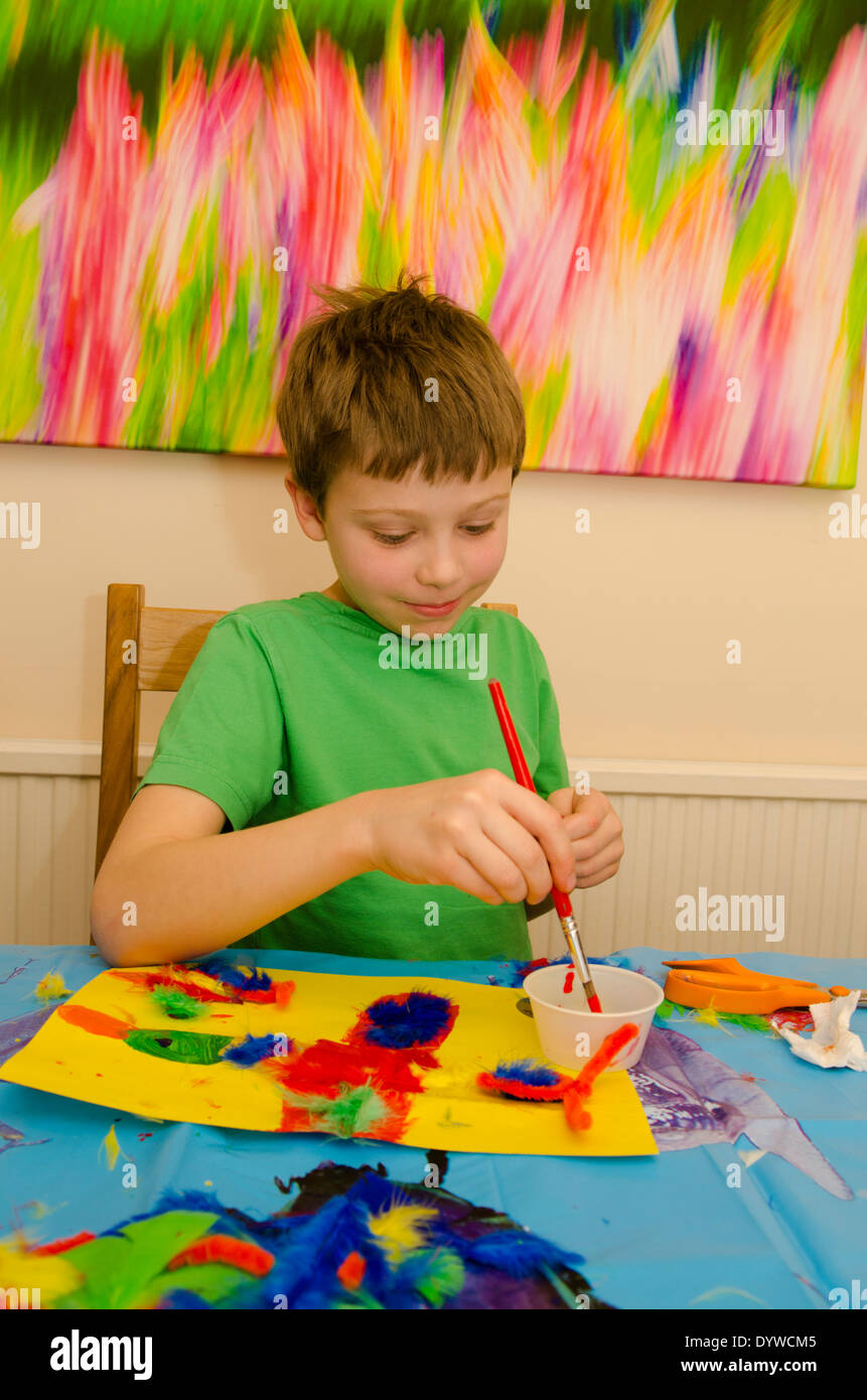 eight year old boy doing arts and craft montage with glue scissors and paint Stock Photo Alamy