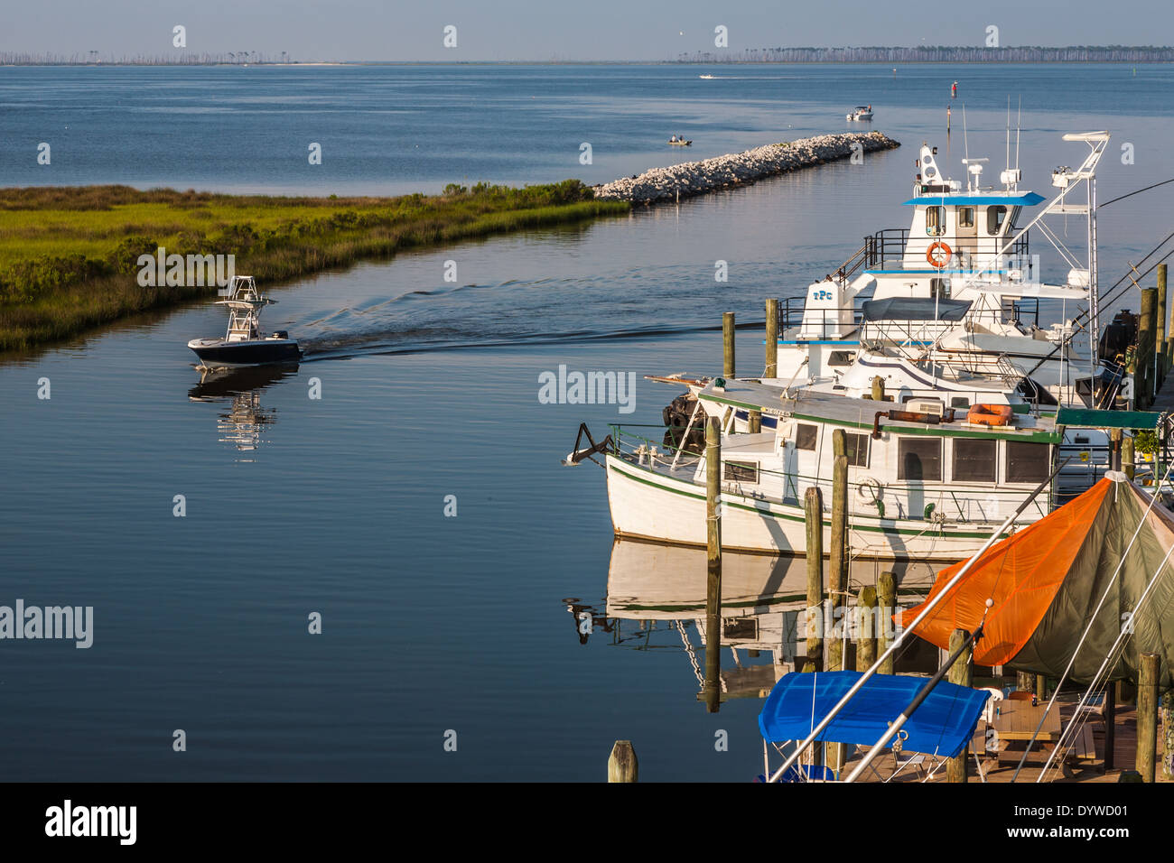 Private and commercial fishing boats docked in the harbor entrance at