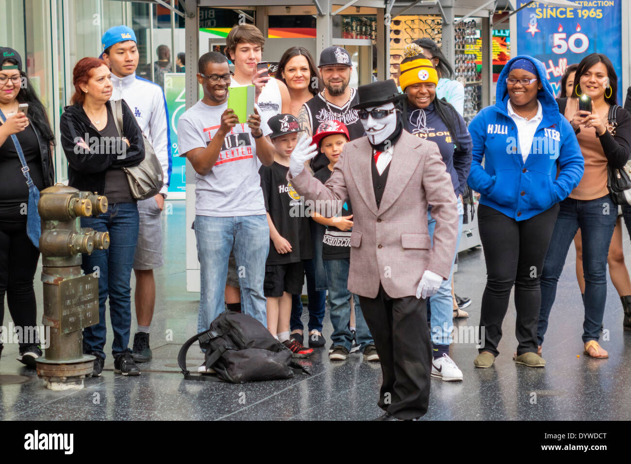 California,LA,Los Angeles,Hollywood Boulevard,movie industry,Hollywood Walk of Fame,street performer,busking tips,costume,Anonymous mask,audience,mime Stock Photo