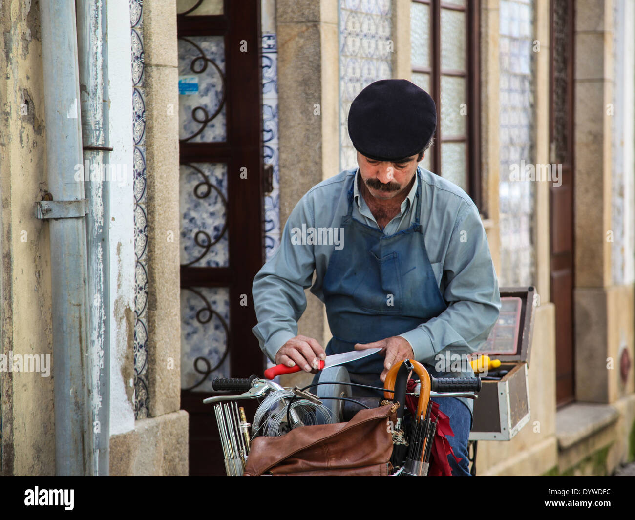 Craftsman sharpening knife on the street in Aveiro, Portugal Stock Photo