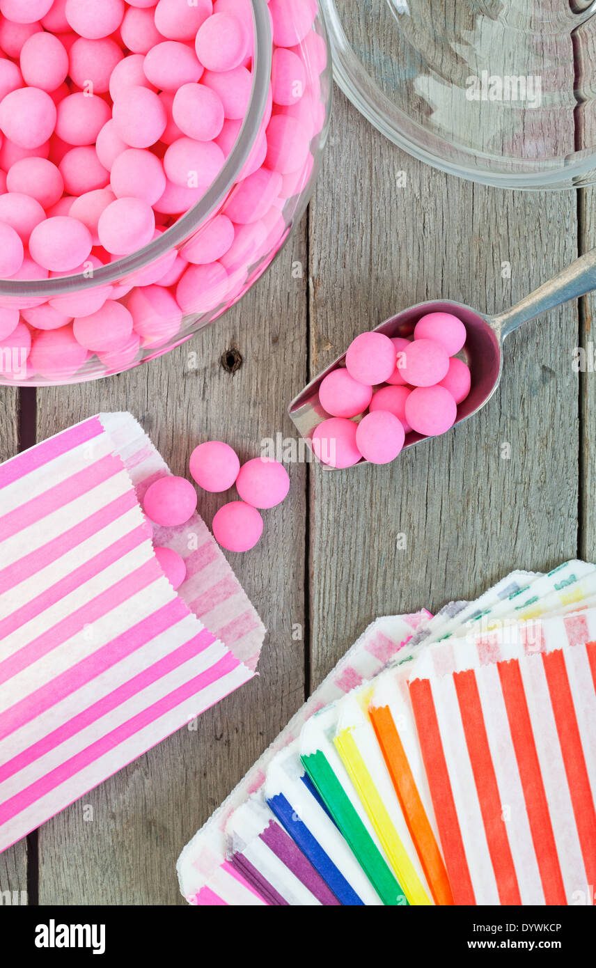 Old fashioned candy jar full of pink peppermints being distributed into
