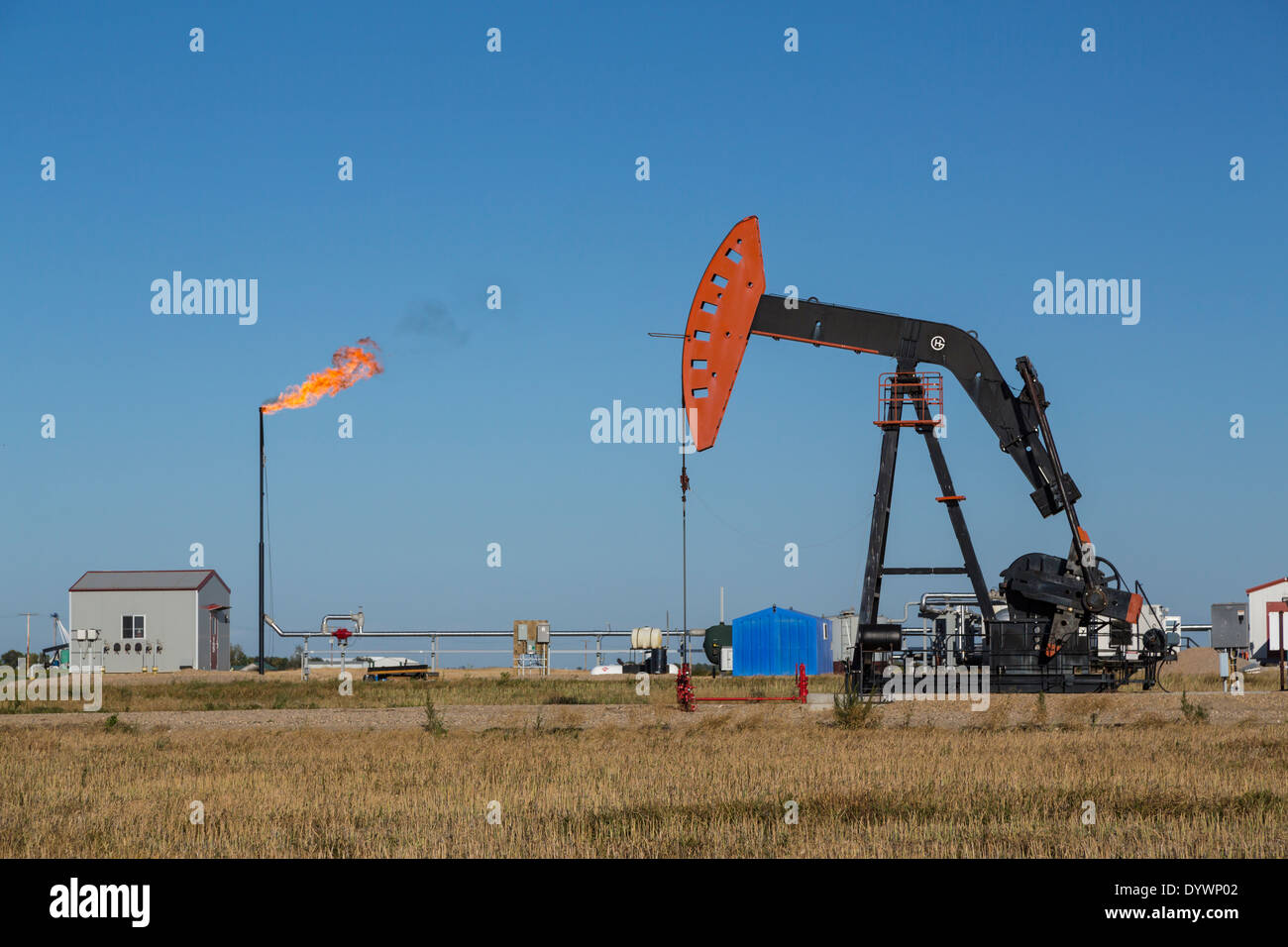 An oil production pumper and flaring gas in the Bakken field near Stoughton, Saskatchewan, Canada. Stock Photo