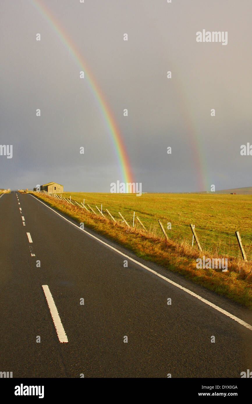 A Double Rainbow Arching over a Road Section Stock Photo
