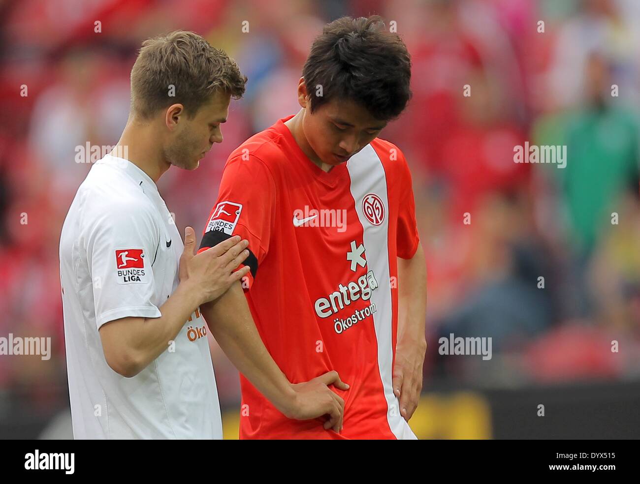 Mainz, Germany. 26th Apr, 2014. Mainz' Ja-Cheol Koo (R), who is from South Korea, looks at the black ribbon he wears to commemorate the victims of the South Korean ferry tragedy next to Benedikt Saller during the German soccer Bundesliga match between 1. FSV Mainz 05 and 1. FC Nuremberg at the Coface Arena in Mainz, Germany, 26 April 2014. Photo: FREDRIK VON ERICHSEN/dpa (ATTENTION: Due to the accreditation guidelines, the DFL only permits the publication and utilisation of up to 15 pictures per match on the internet and in online media during the match.)/dpa/Alamy Live News Stock Photo