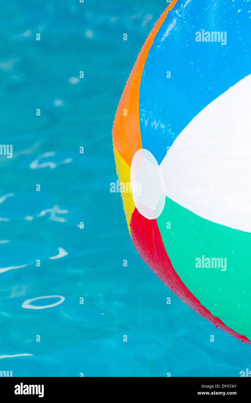 brightly coloured beach ball floating on clear blue water Stock Photo