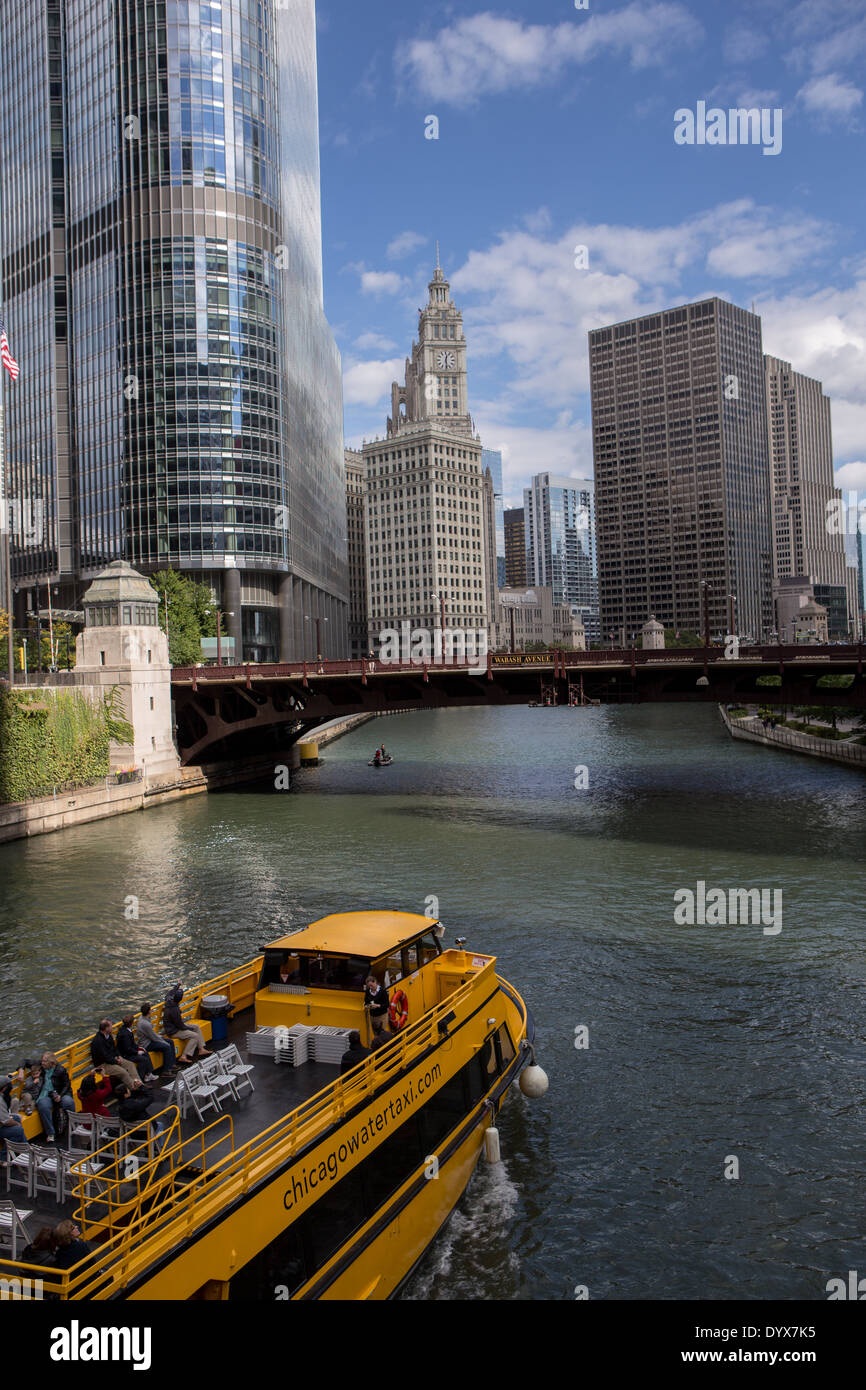A water taxi travels the Chicago River by State Street in Chicago, IL ...