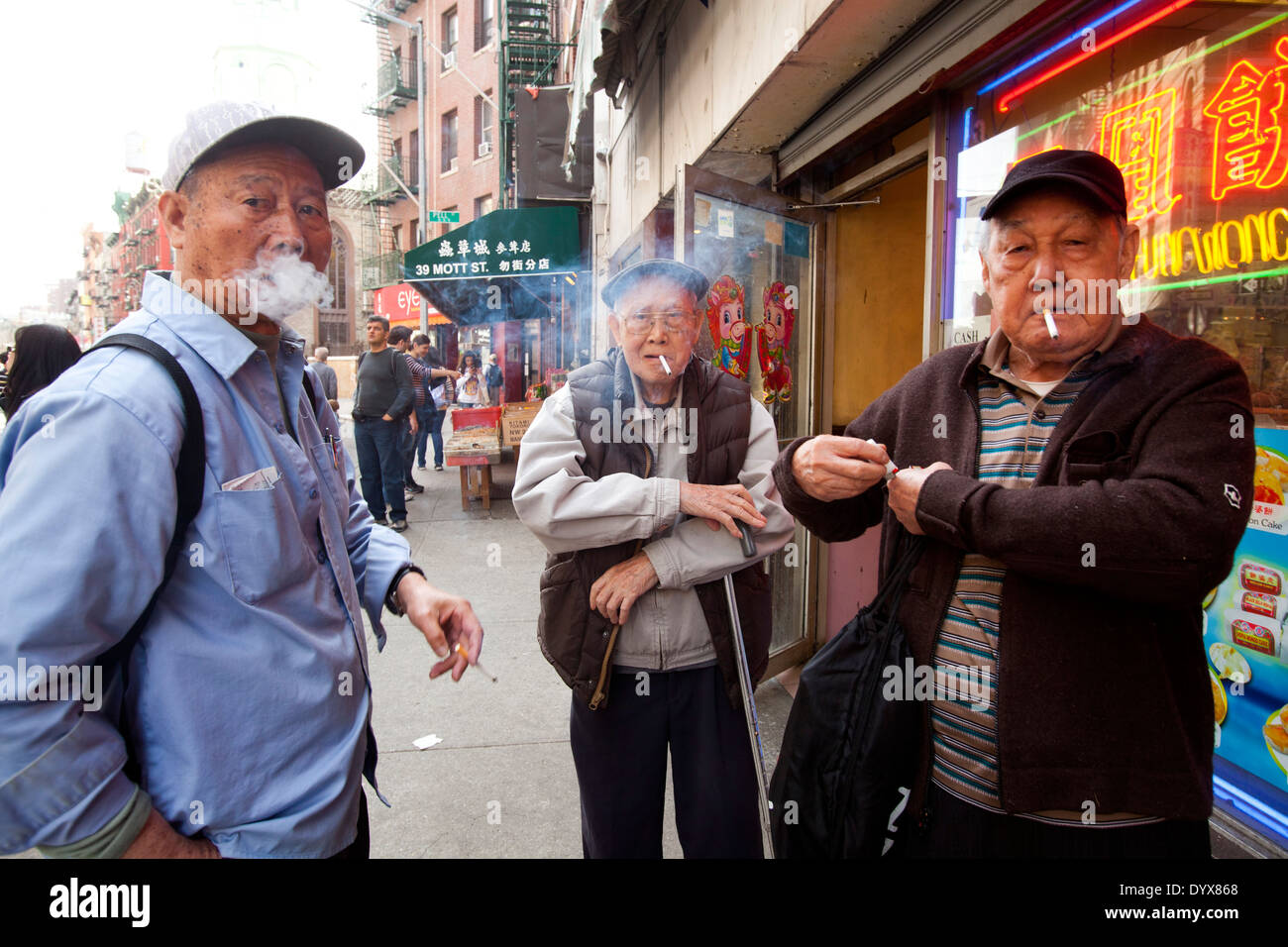 Chinese men smoking cigarettes, Chinatown, Manhattan, New York City, New York Stock Photo