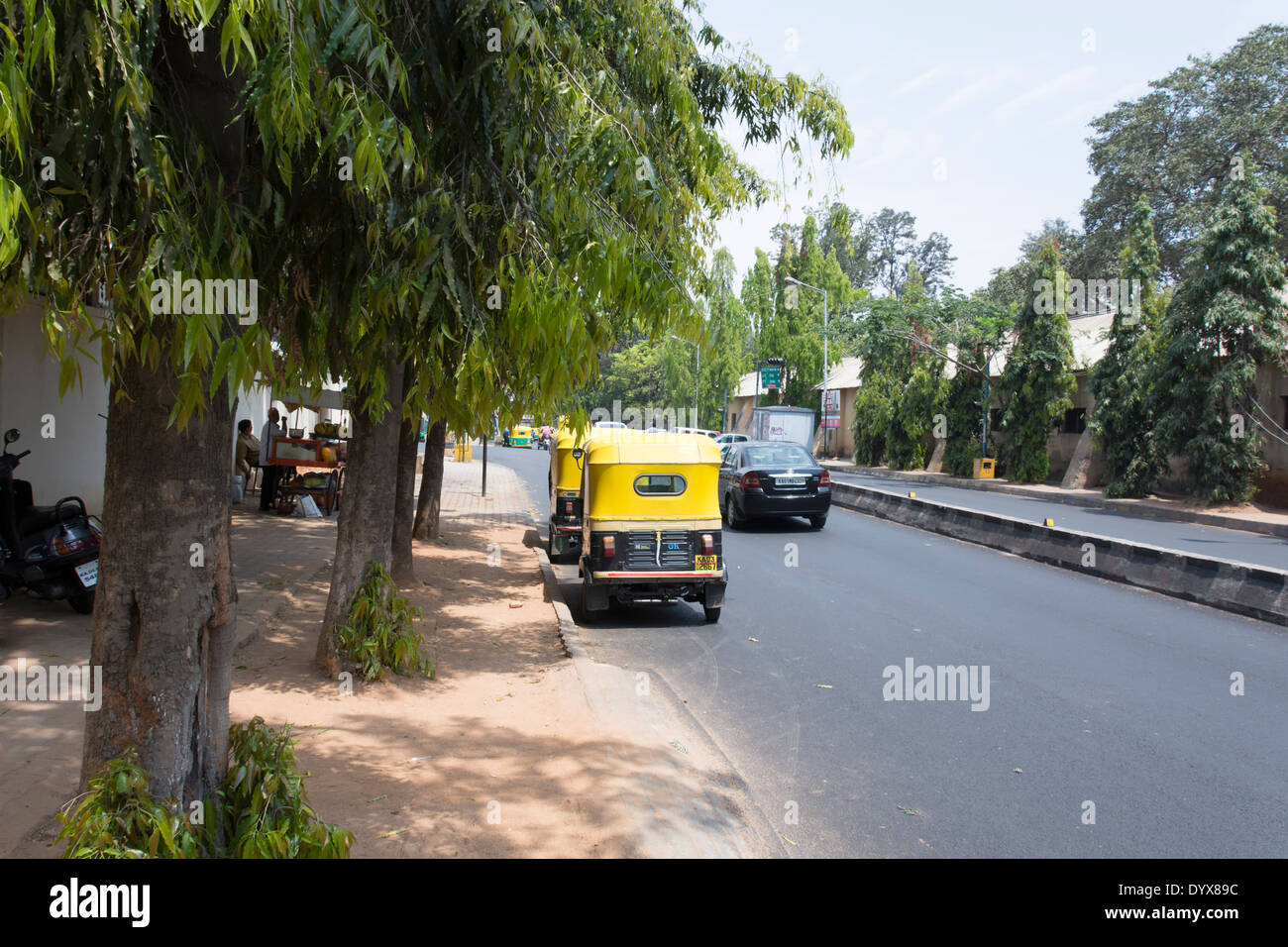 A street scene showing Auto Rickshaws with their drivers resting in Bangalore, Karnatake, India Stock Photo