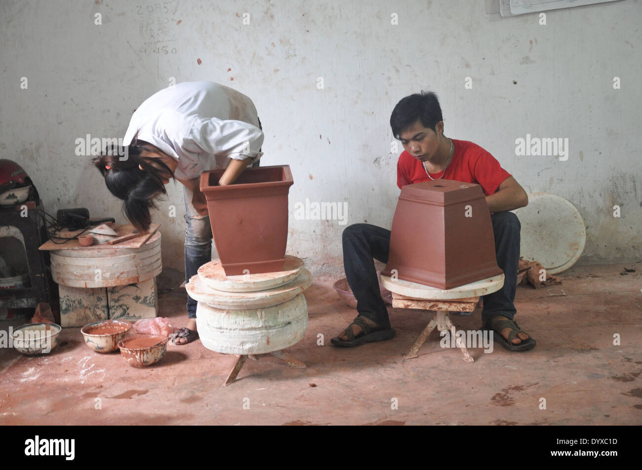 Two potters work on ceramic pots at Bat Trang pottery village near
