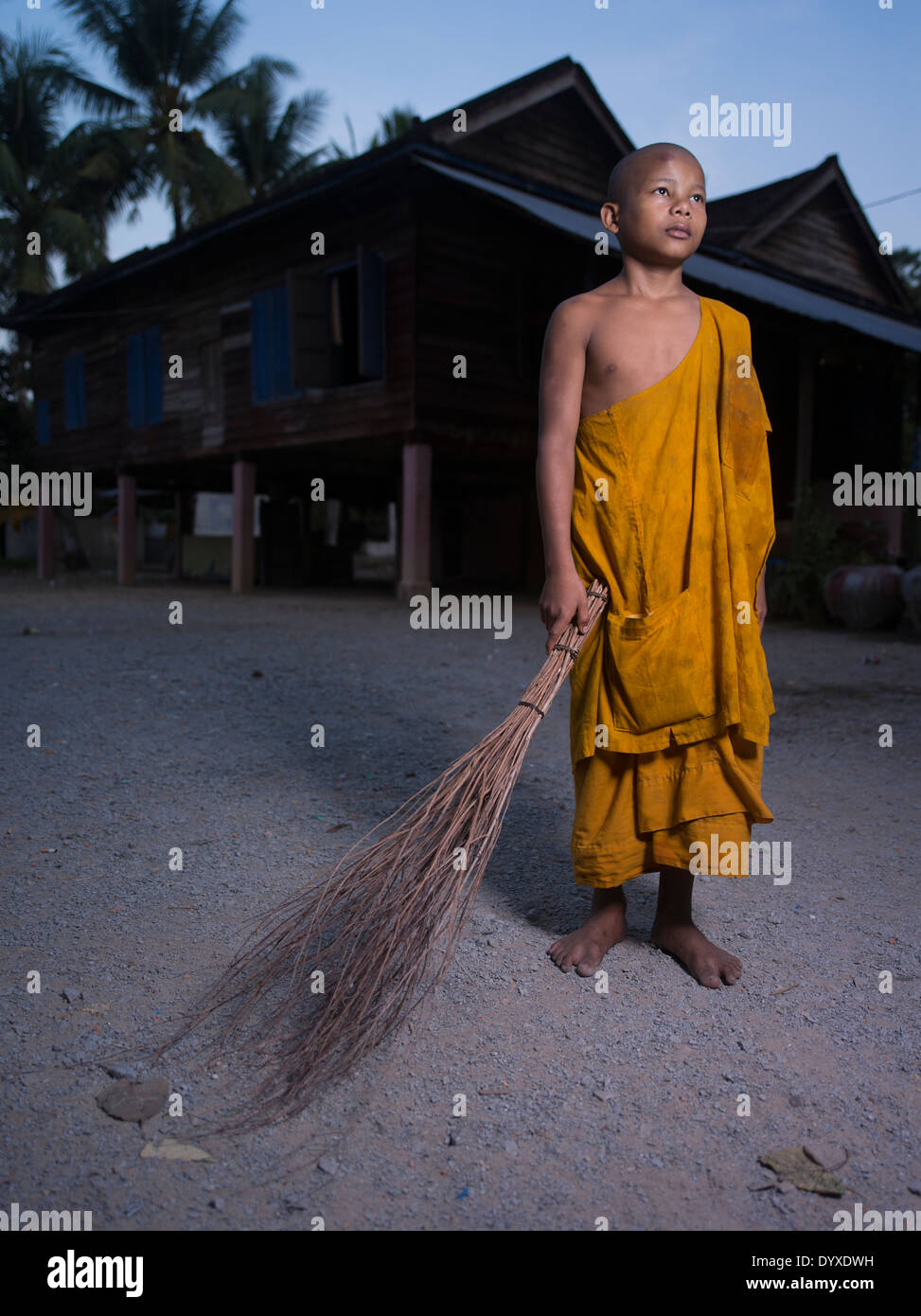 Cambodian Buddhist monk sweeping grounds at dawn. Angkor Wat Temple, Siem Reap, Cambodia Stock Photo