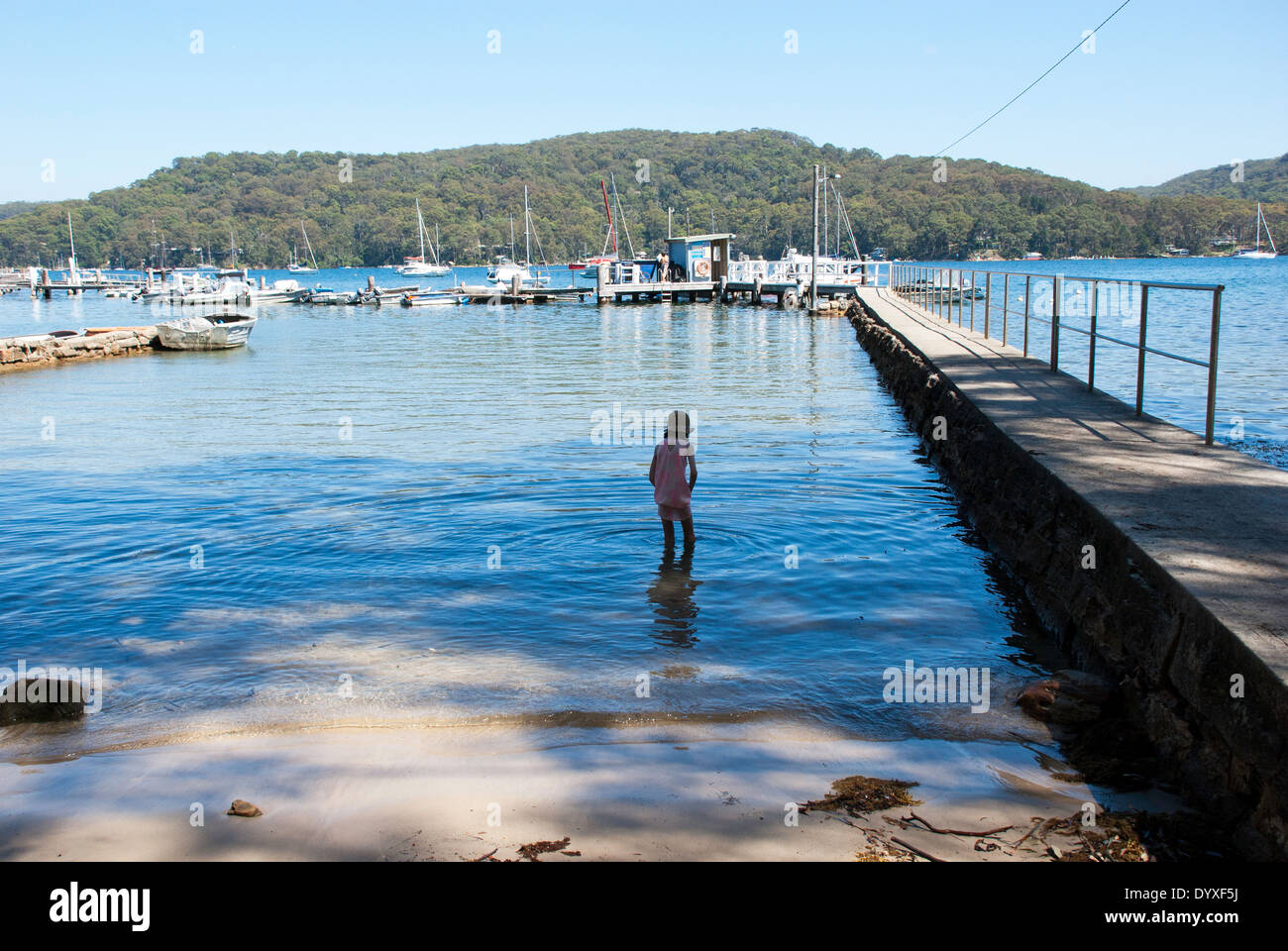 A young girl wading in the water at Scotland Island, Pittwater, Sydney, Australia Stock Photo