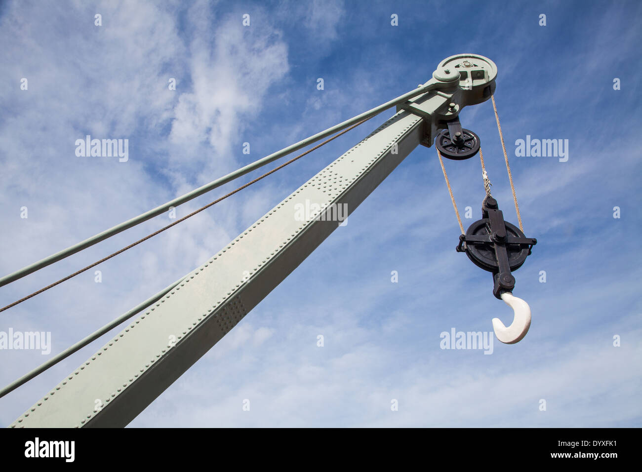 The hook end of an old crane against a blue sky Stock Photo