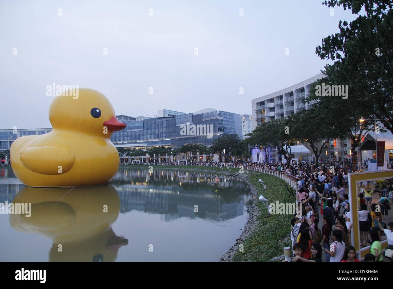 (140427) -- HO CHI MINH CITY, April 27 (Xinhua) -- People watch the giant rubber duck in the Phu My Hung residential area in Ho Chi Minh (HCM) City, Vietnam, April 26, 2014. A 18-meter-tall rubber duck, which has captivated people across the world, will be displayed at the Crescent Lake in the Phu My Hung residential area of HCM city from April 27 to May 31, local media reported Saturday. Designed by Dutch artist Florentijn Hofman, the rubber duck started a tour named 'Spreading Joys around the World' in 2007. HCM City will be the 16th venue where it is displayed. (Xinhua/Tao Jun) (dzl) Stock Photo