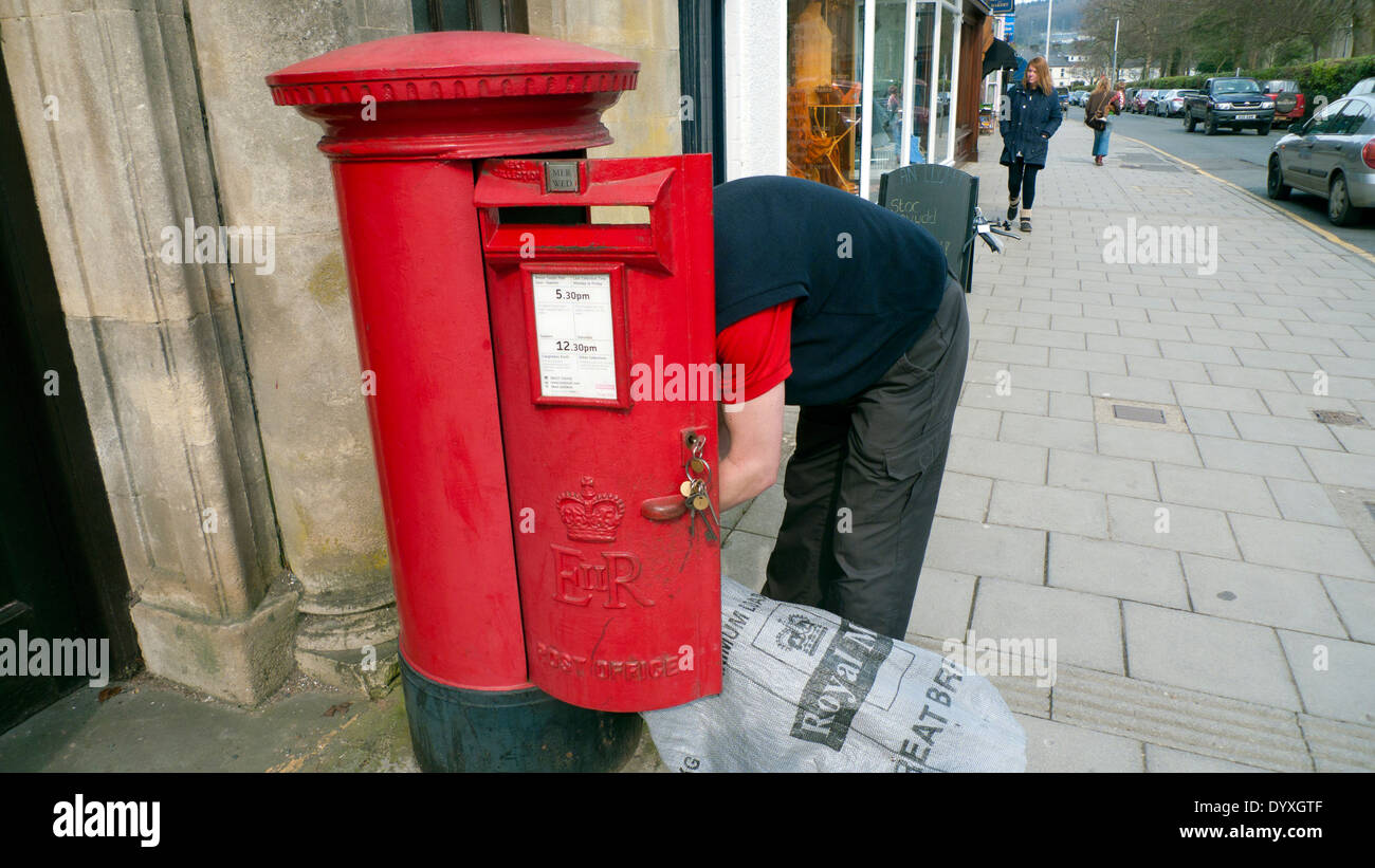 Postman loading up a mail sack from red post box in Lampeter Ceredigion Wales UK KATHY DEWITT Stock Photo