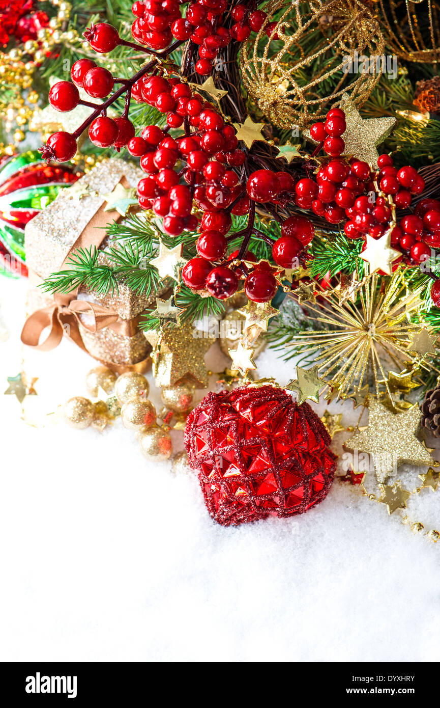 festive decoration with red baubles, golden garlands, christmas tree and berries branches Stock Photo