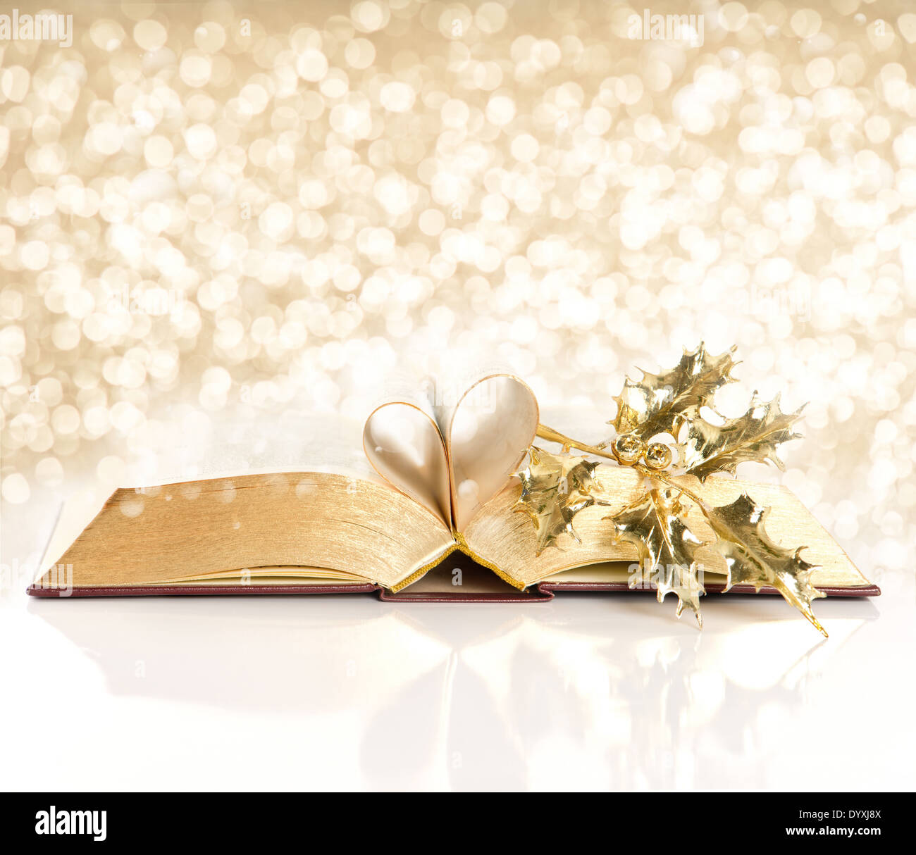 open vintage book with golden pages. bible with golden decoration over shiny lights background Stock Photo