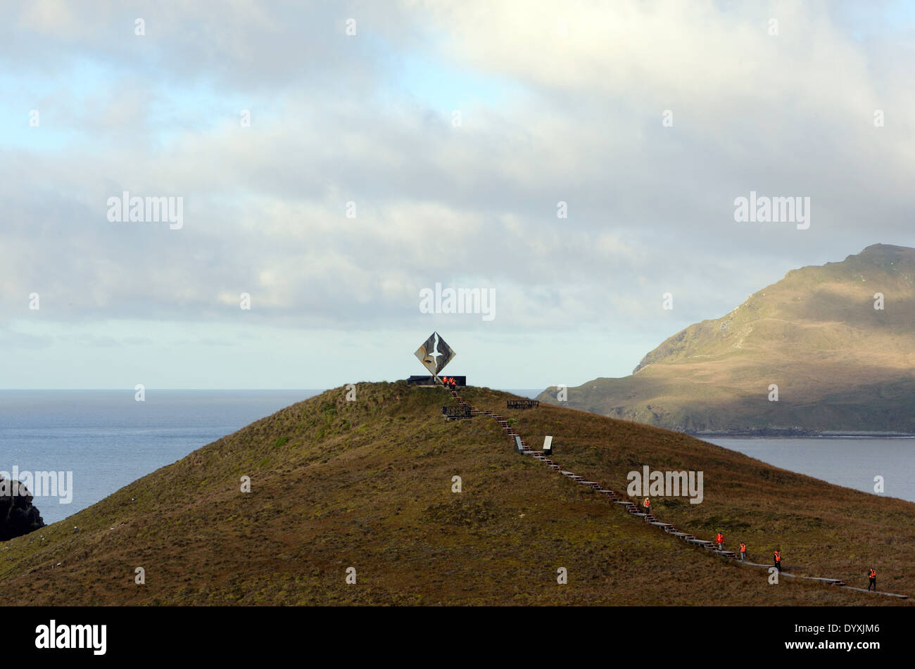 Tourists in orange life jackest visit the albatross memorial, Monumento Cabo de Hornos, to those lost  at sea. Cape Horn Stock Photo