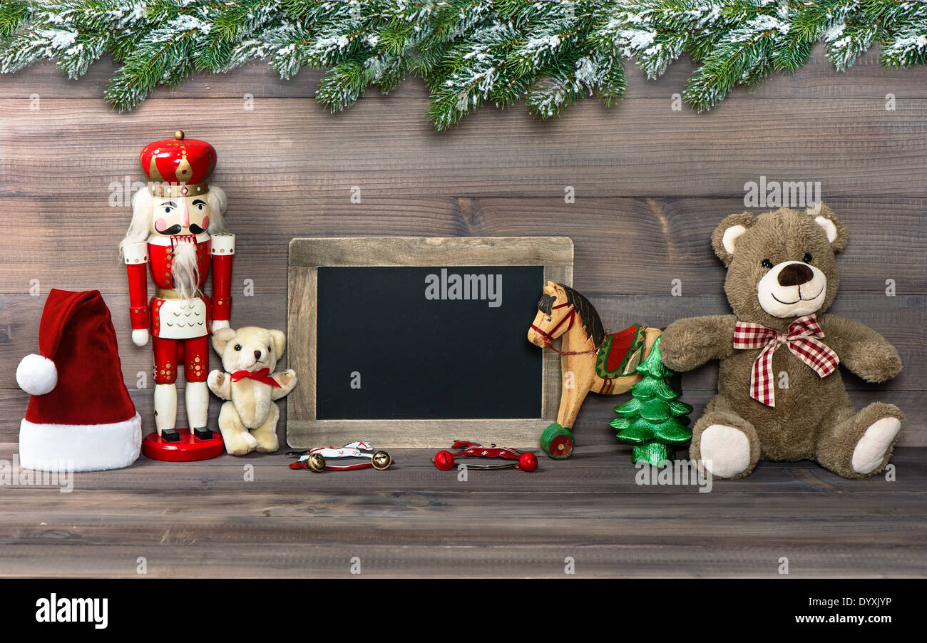 nostalgic christmas decoration with antique toys, pine tree branches and blackboard for your text. retro style toned picture Stock Photo