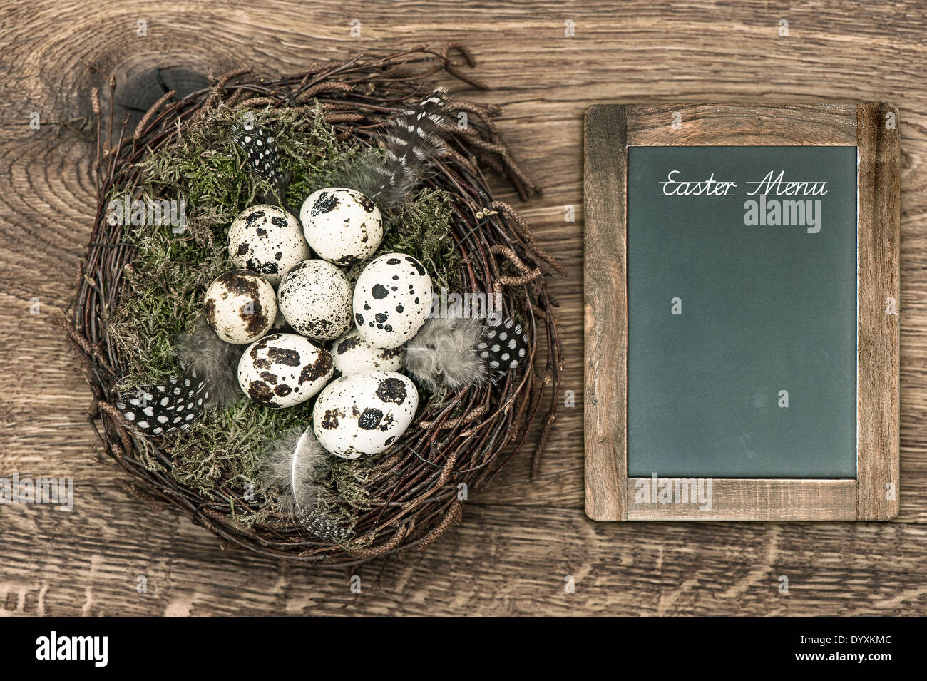 birds eggs in nest on rustic wooden background. vintage easter decoration with blackboard and sample text Easter Menu Stock Photo