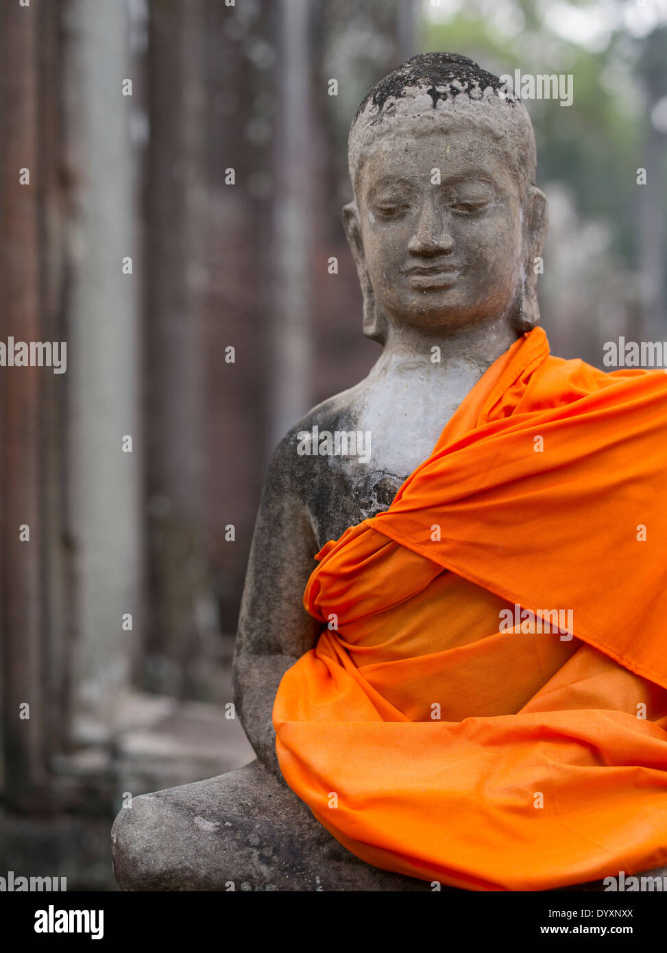 Buddhist statue in orange robes at Bayon Temple, Angkor Thom, Siem Reap, Cambodia Stock Photo