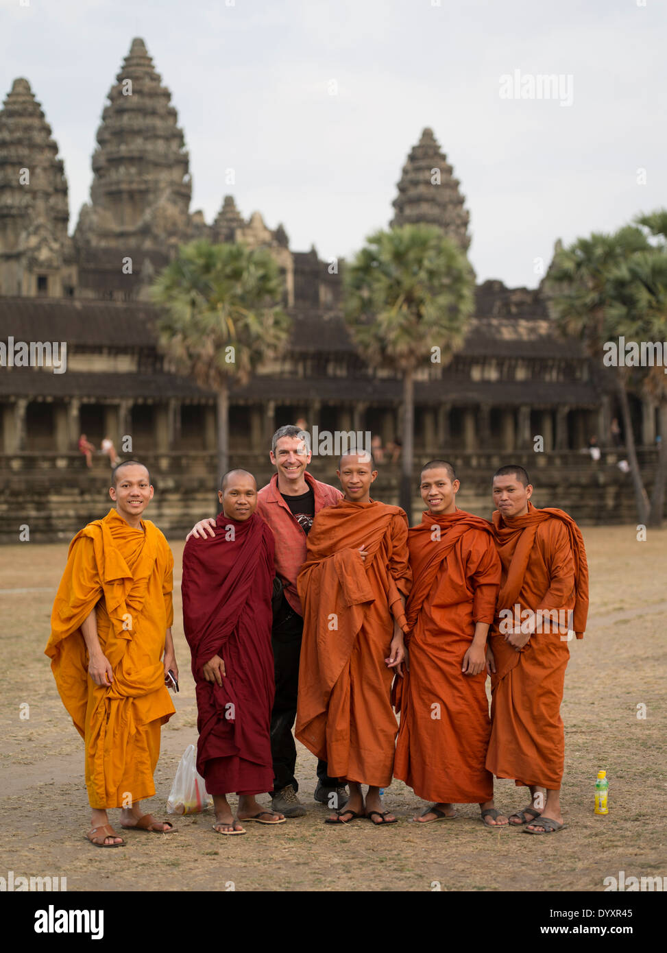 Western tourist with Buddhist monks in traditional robes at Angkor Wat, Siem Reap, Cambodia Stock Photo