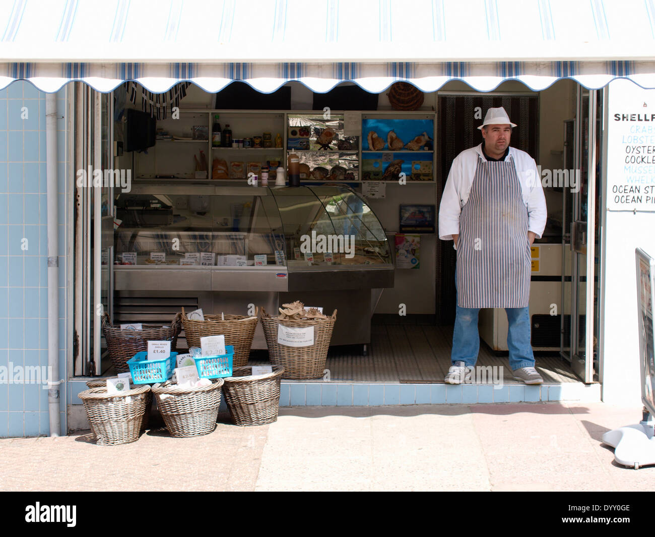 Fishmonger standing at the front of his shop, Newquay, Cornwall, UK Stock Photo