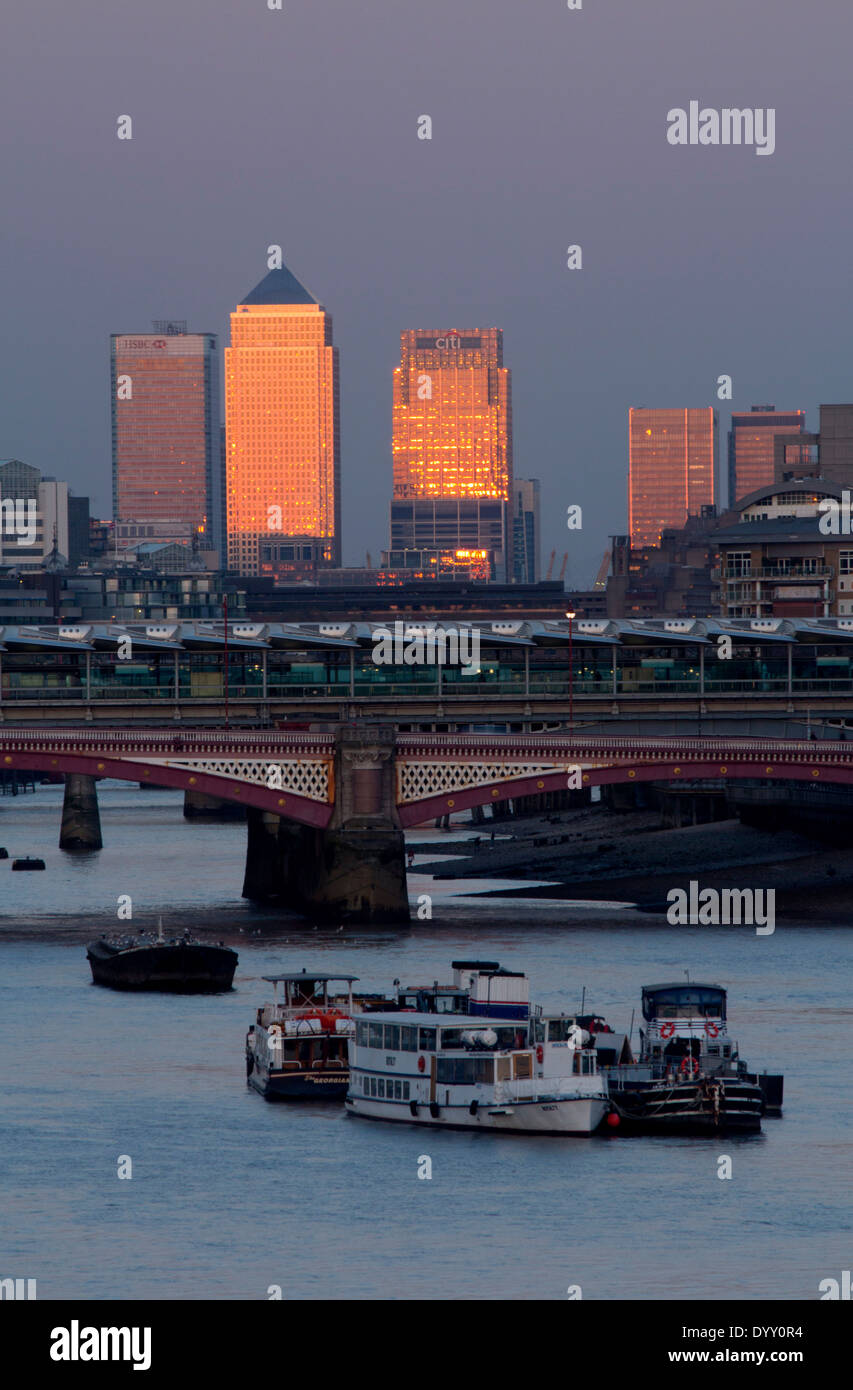 Canary Wharf towers at sunset from Waterloo bridge with River Thames and Blackfriars Bridge in foreground London England UK Stock Photo