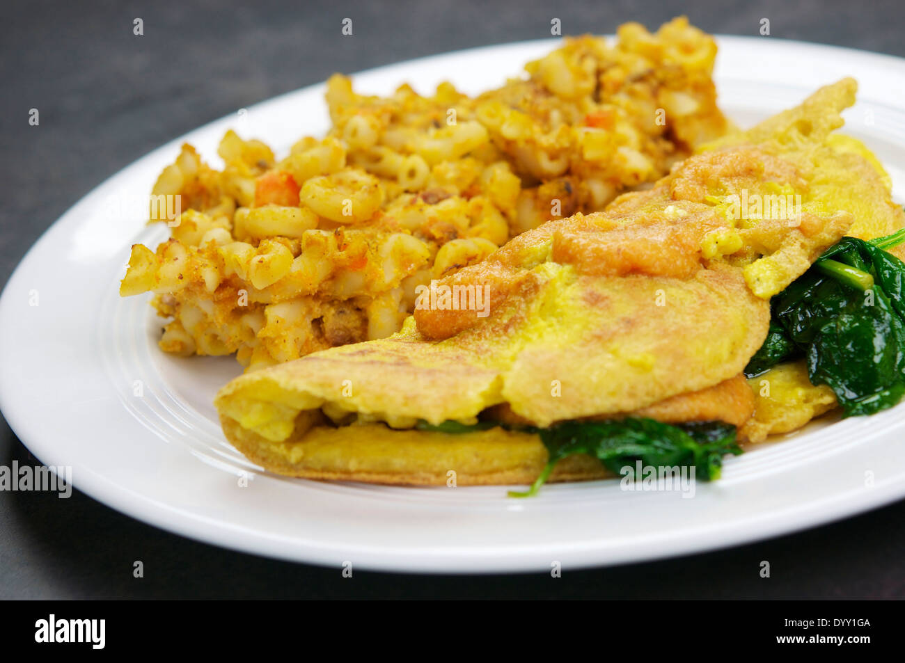 Macaroni pasta with a cheddar type sauce baked in the oven to a nice crispy texture. Served with an egg free spinach omelet. Stock Photo