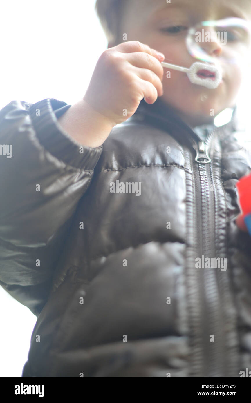 3 year old boy blowing bubbles Stock Photo