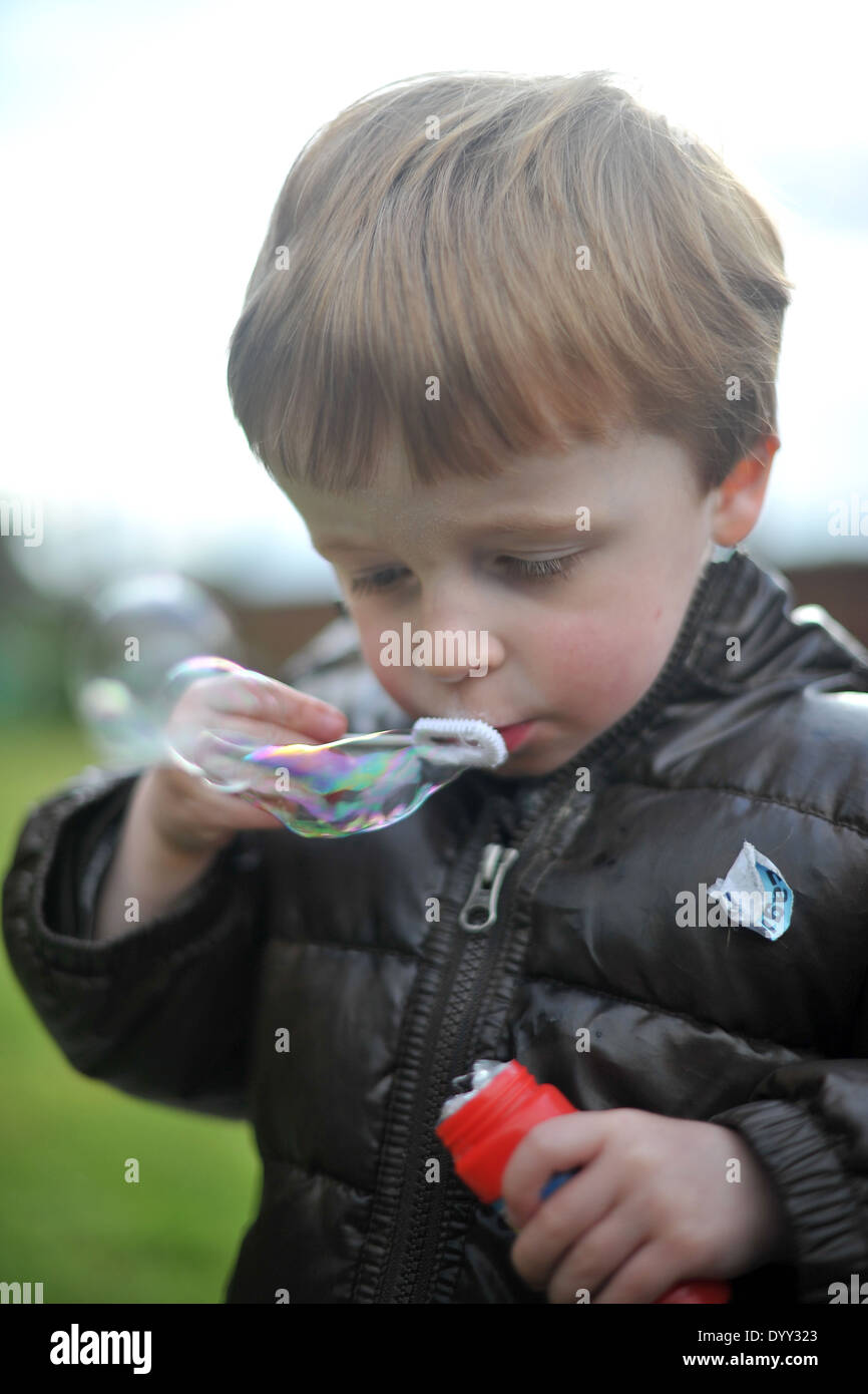 3 year old boy blowing bubbles Stock Photo