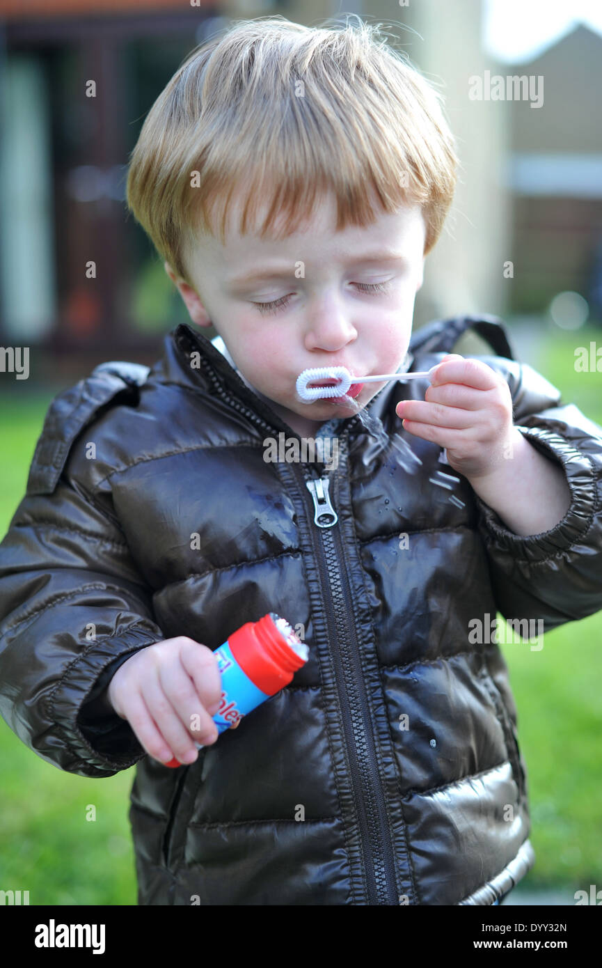 3 year old boy blowing bubbles Stock Photo