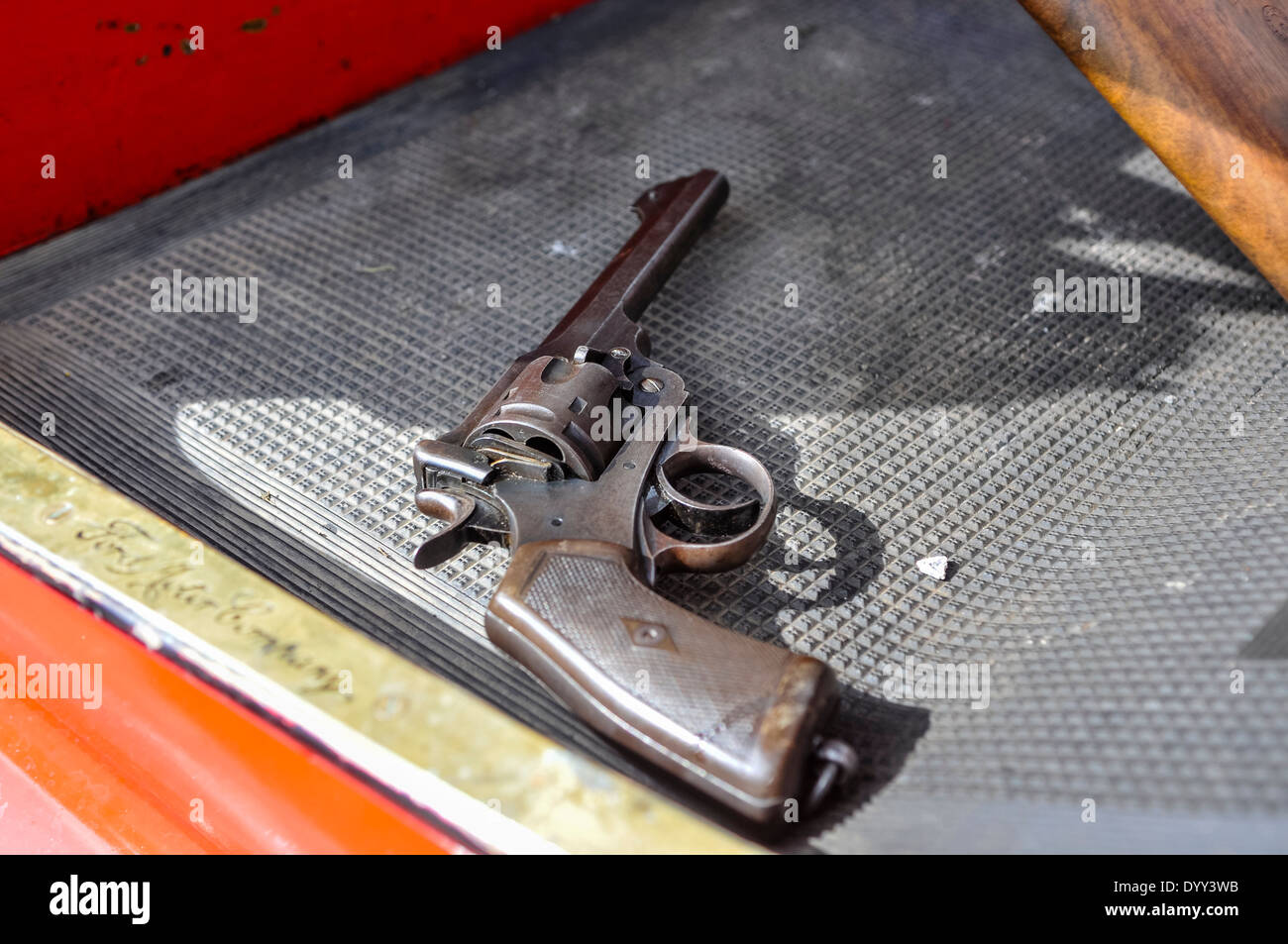 A WW1 era revolver lying on the footwell of an old Ford car Stock Photo