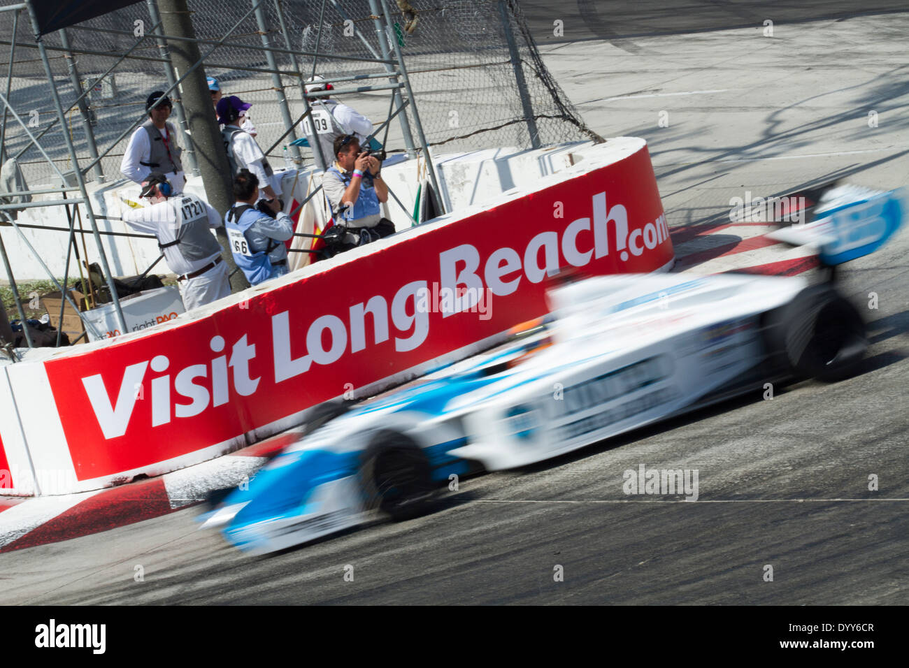 Unidentified Indy racing car streaks by the "visit Long Beach" sign at