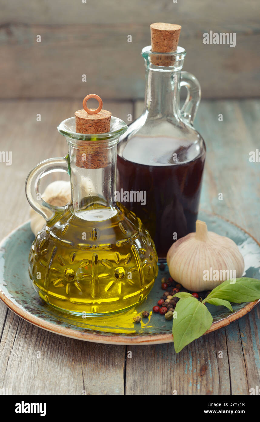 Olive oil and wine vinegar in bottles on wooden background Stock Photo
