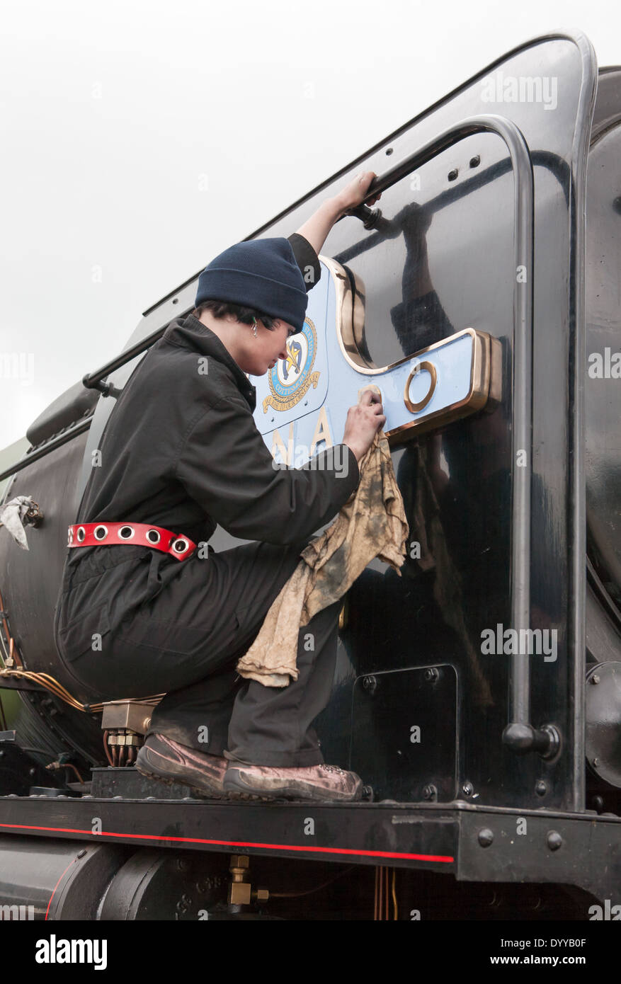 Young woman polishing the nameplate of steam locomotive Tornado, Shildon Co. Durham, England, UK Stock Photo