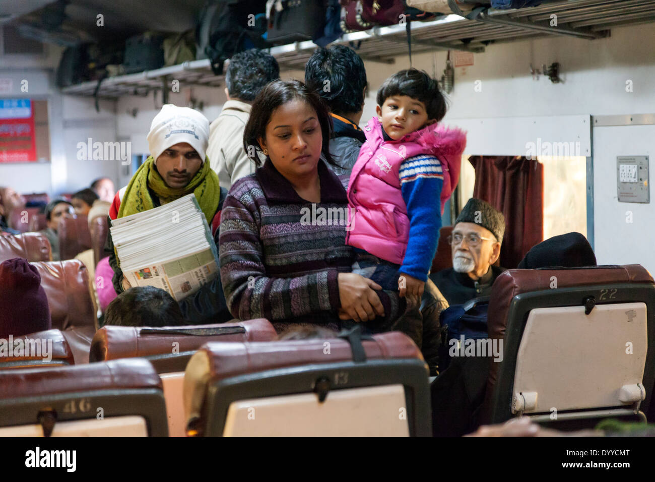 New Delhi, India. Passengers, Mother and Child, Newspaper Vendor in High-speed Delhi-to-Agra Train. Stock Photo