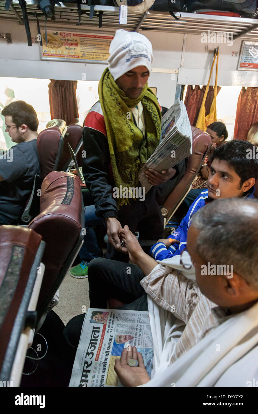 New Delhi, India. Newspaper Vendor Selling a Paper on the Morning Delhi-Agra Express Train. Stock Photo