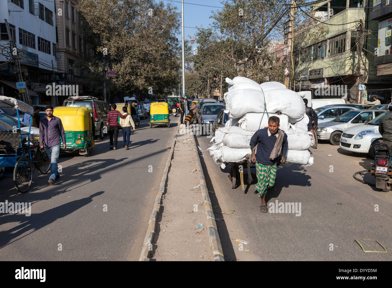 New Delhi, India. Manual Labor Moves Goods along a Street in Central Delhi. Stock Photo