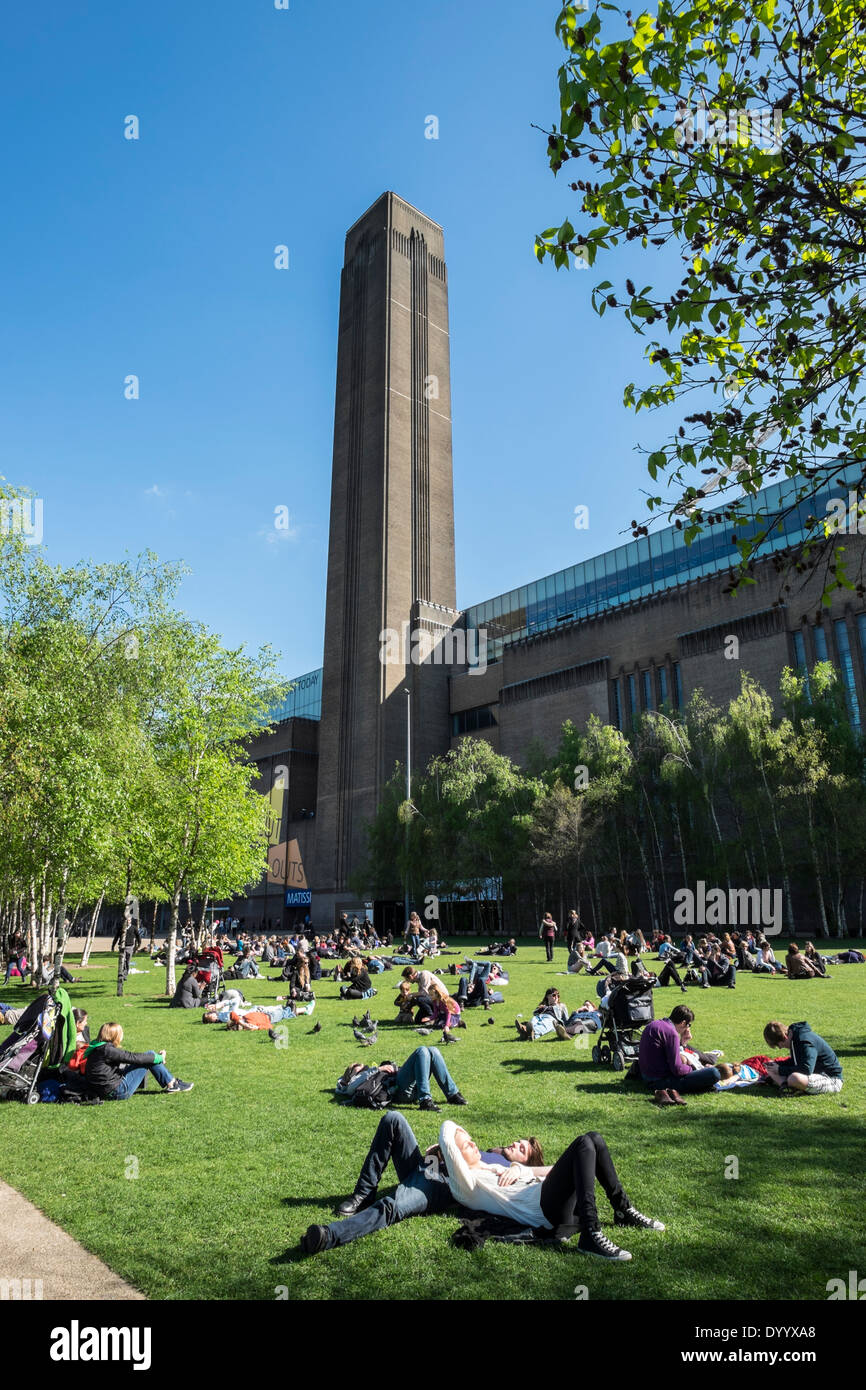 People relaxing in park in front of Tate Modern art gallery in London United Kingdom Stock Photo