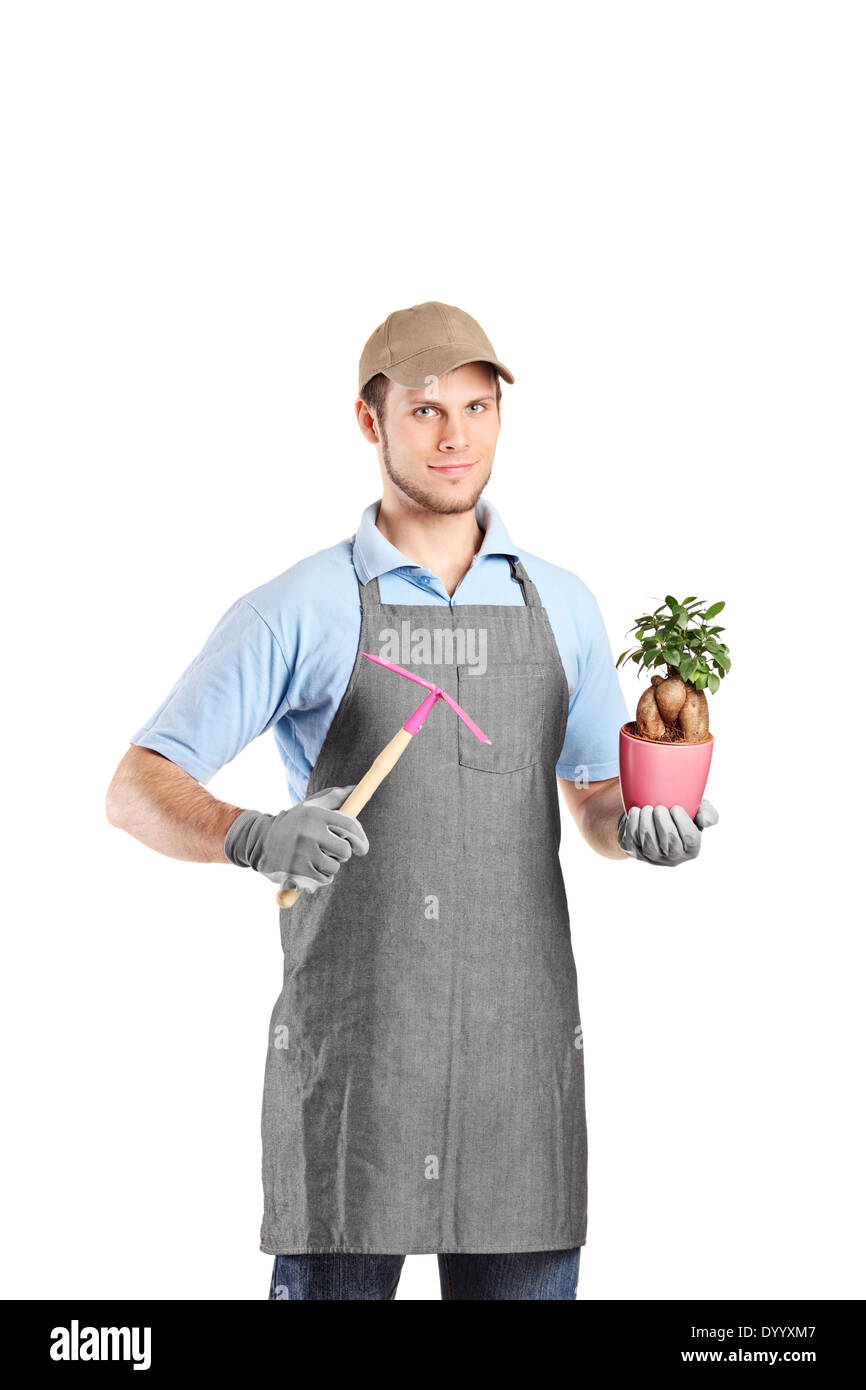 Male gardener holding a mattock and a plant Stock Photo