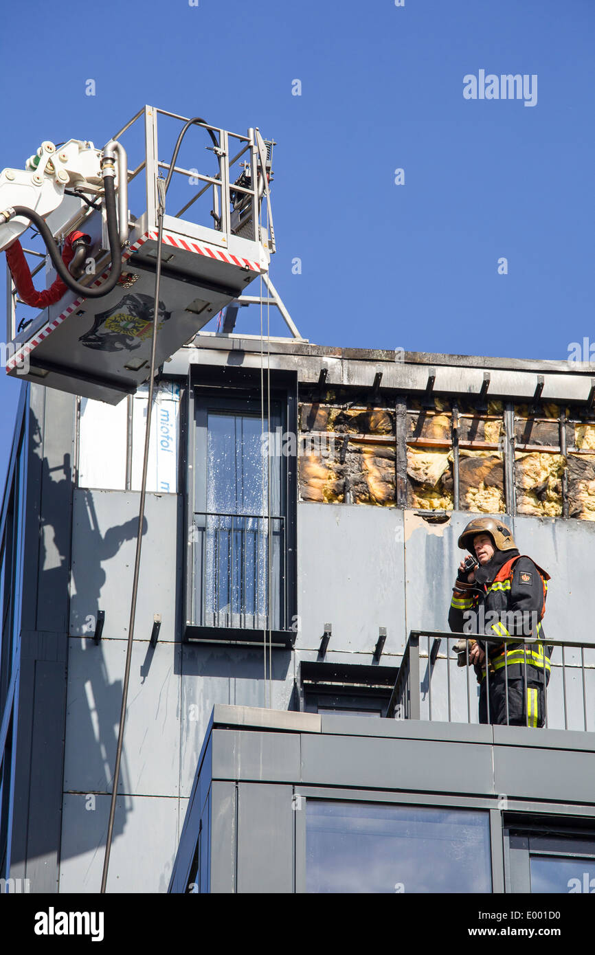 Fireman communicating about procedures on top of roof Stock Photo