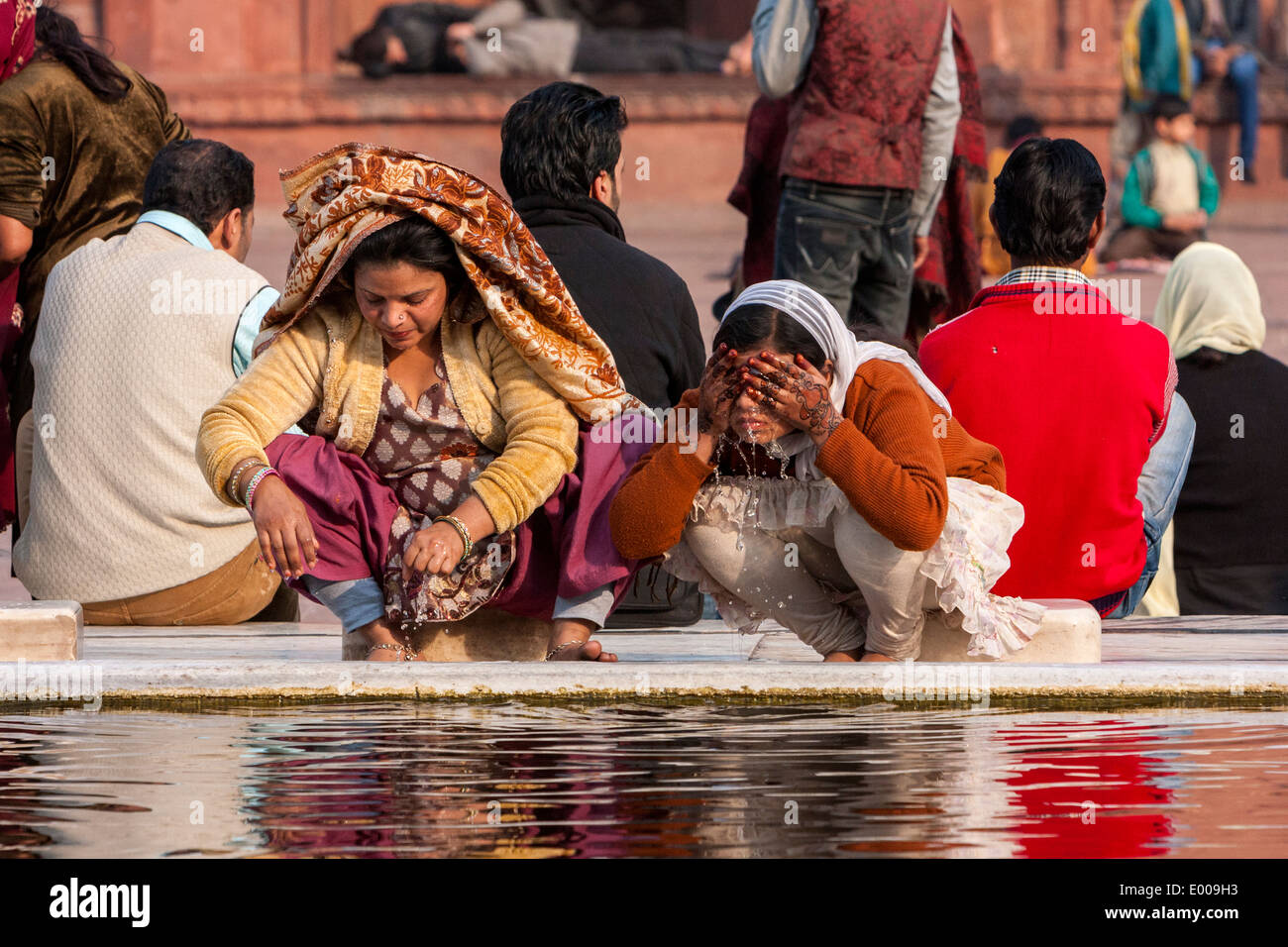 New Delhi, India. Muslim Women Performing Ablutions before Prayers, Jama Masjid (Friday Mosque). Note Henna Tattoos on Hands. Stock Photo