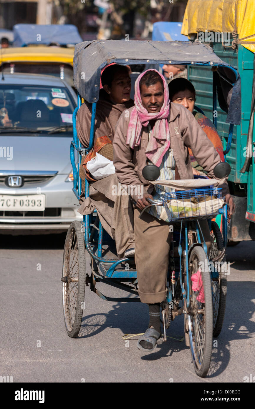 New Delhi, India. Rickshaw with Driver and Passengers in Downtown Delhi. Stock Photo