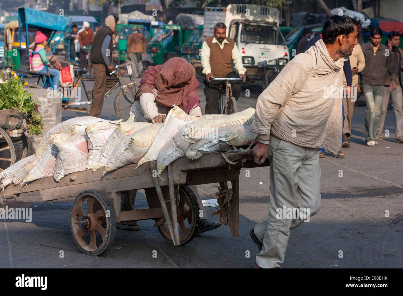 New Delhi, India. Using Manpower to Move Goods along a Downtown Street. Stock Photo